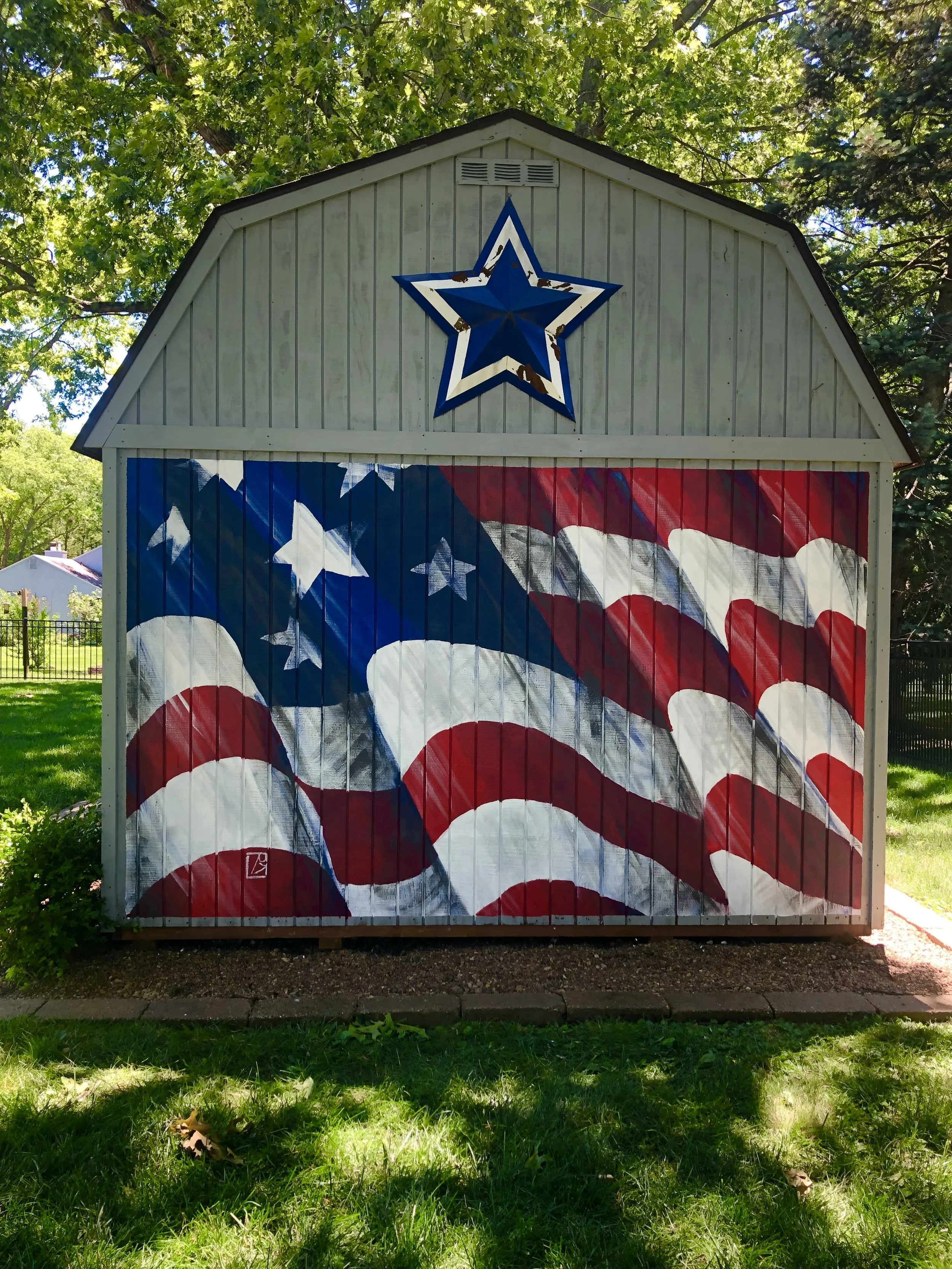 Flag mural on side of shed in Mahomet, Illinois by Leslie Kimble Art