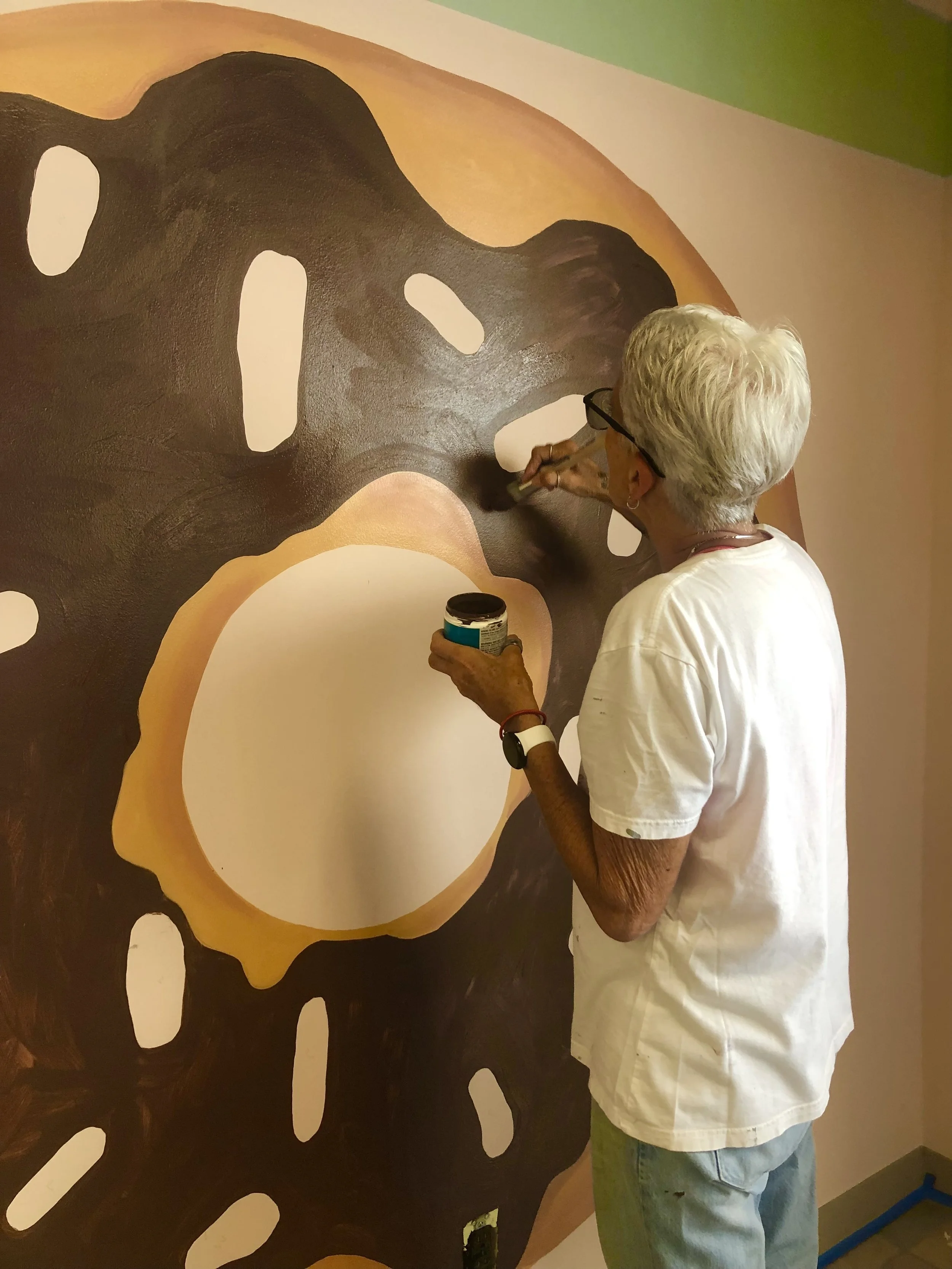 Process photo of donut murals, Laurie Martin paints for Leslie Kimble Art
