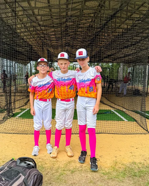 Three youth baseball players in ice cream drip jerseys.