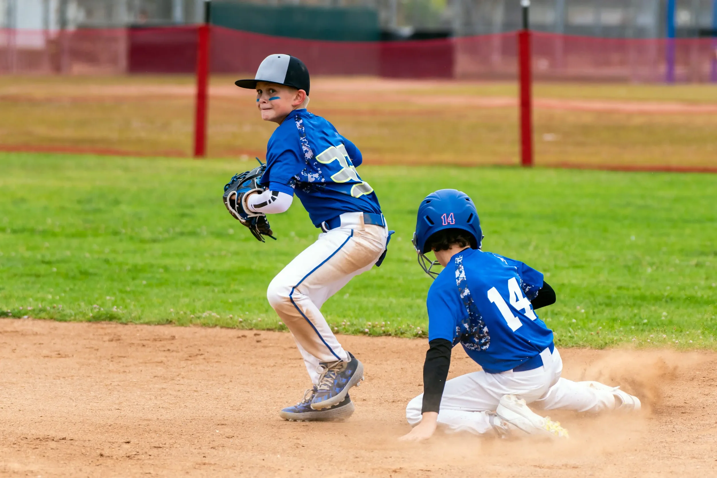 Little League baseball player in a screen-print stock camo jersey.