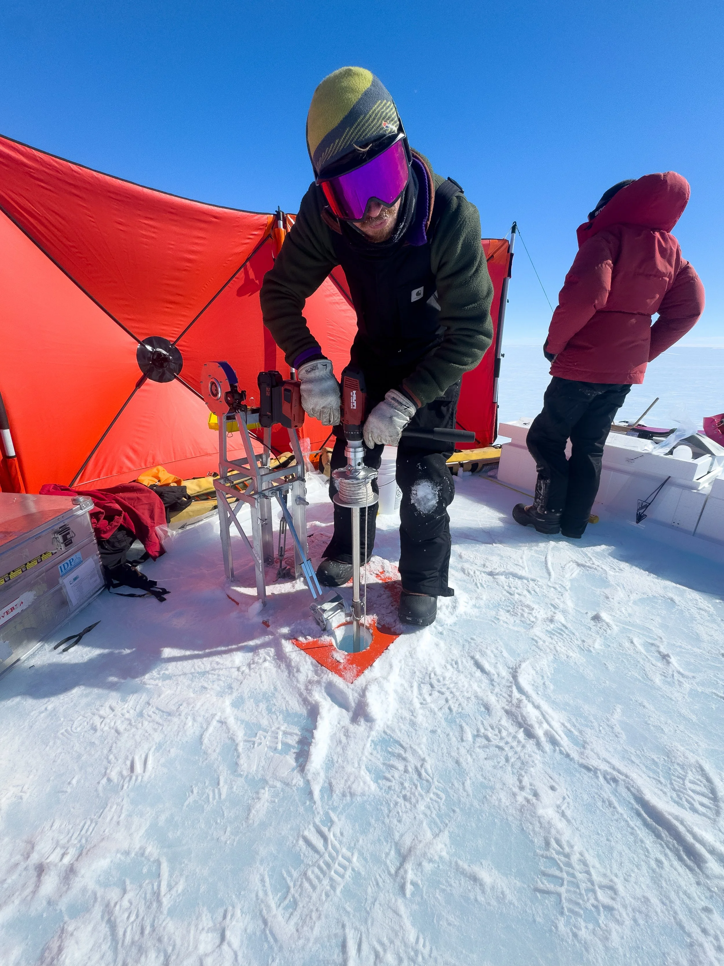 Ice Core Handler Ivo Strawson operating the Sidewinder hand auger system at the Allan Hills during the 2025-2026 field season. Photo by Martin Froger Silva.