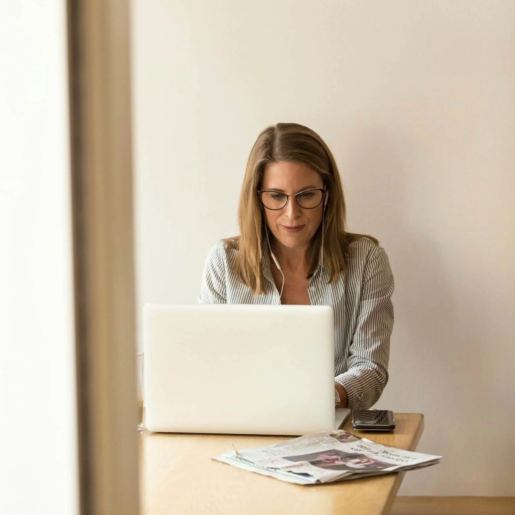 A laptop and a smartphone mockup of Squarespace site design for a creative copywriter, dark background.