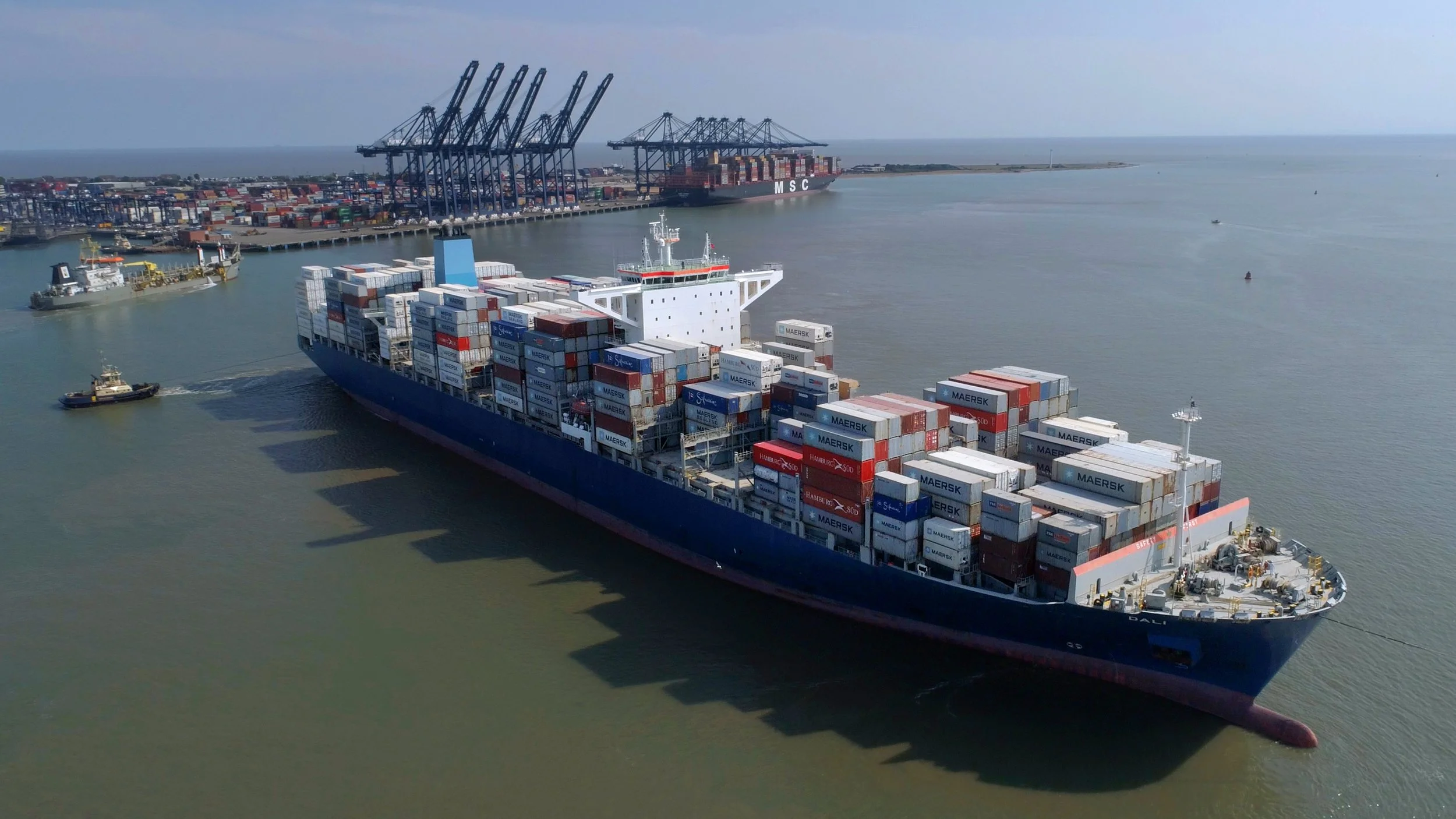 Aerial drone view of London Gateway container port on the River Thames, showing vast rows of shipping containers, gantry cranes and large-scale logistics infrastructure.