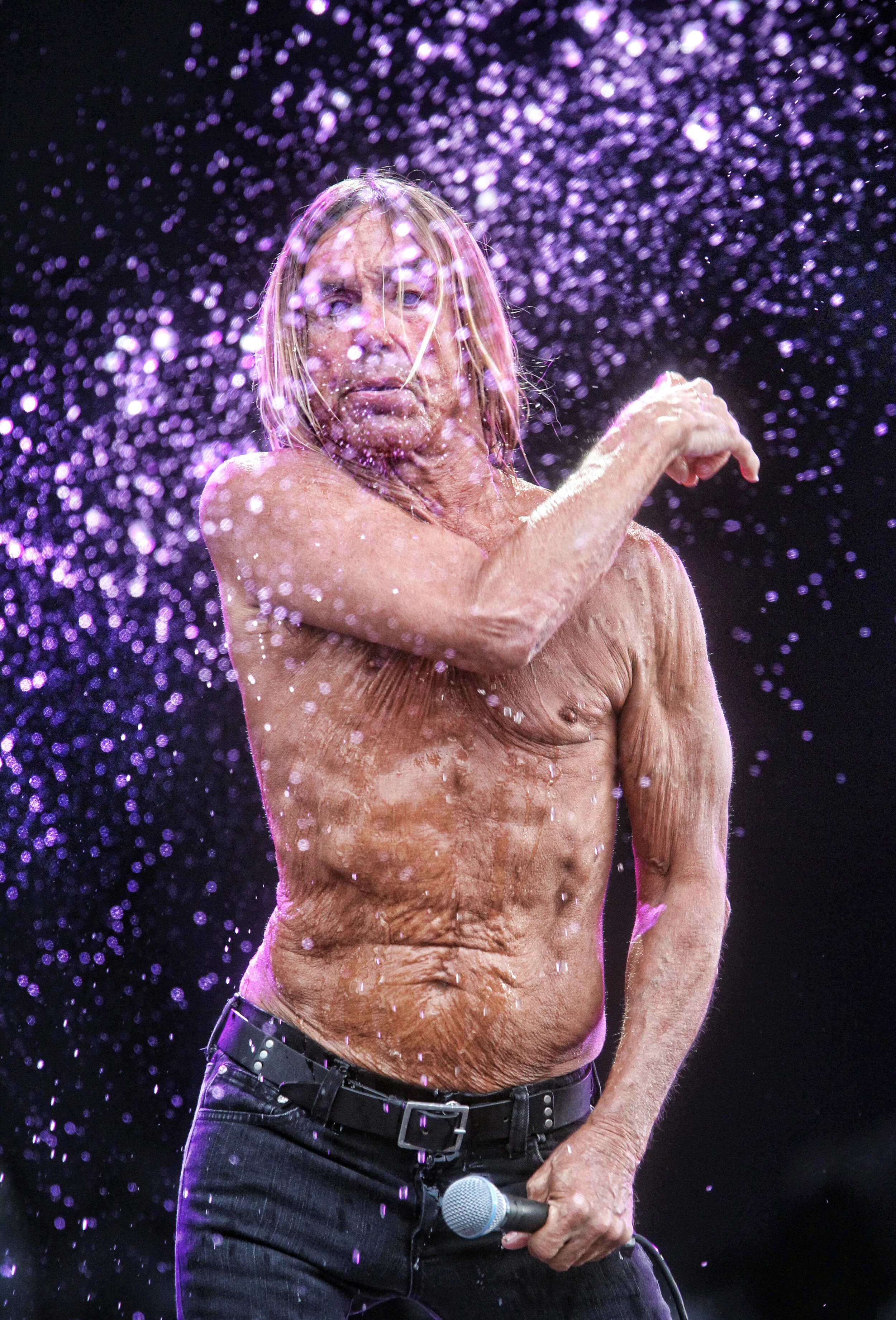 Iconic Photograph of Iggy Pop of Iggy and the Stooges throwing a water bottle surrounded by spray, as he performs at the Hard Rock Calling music festival in Hyde Park, London