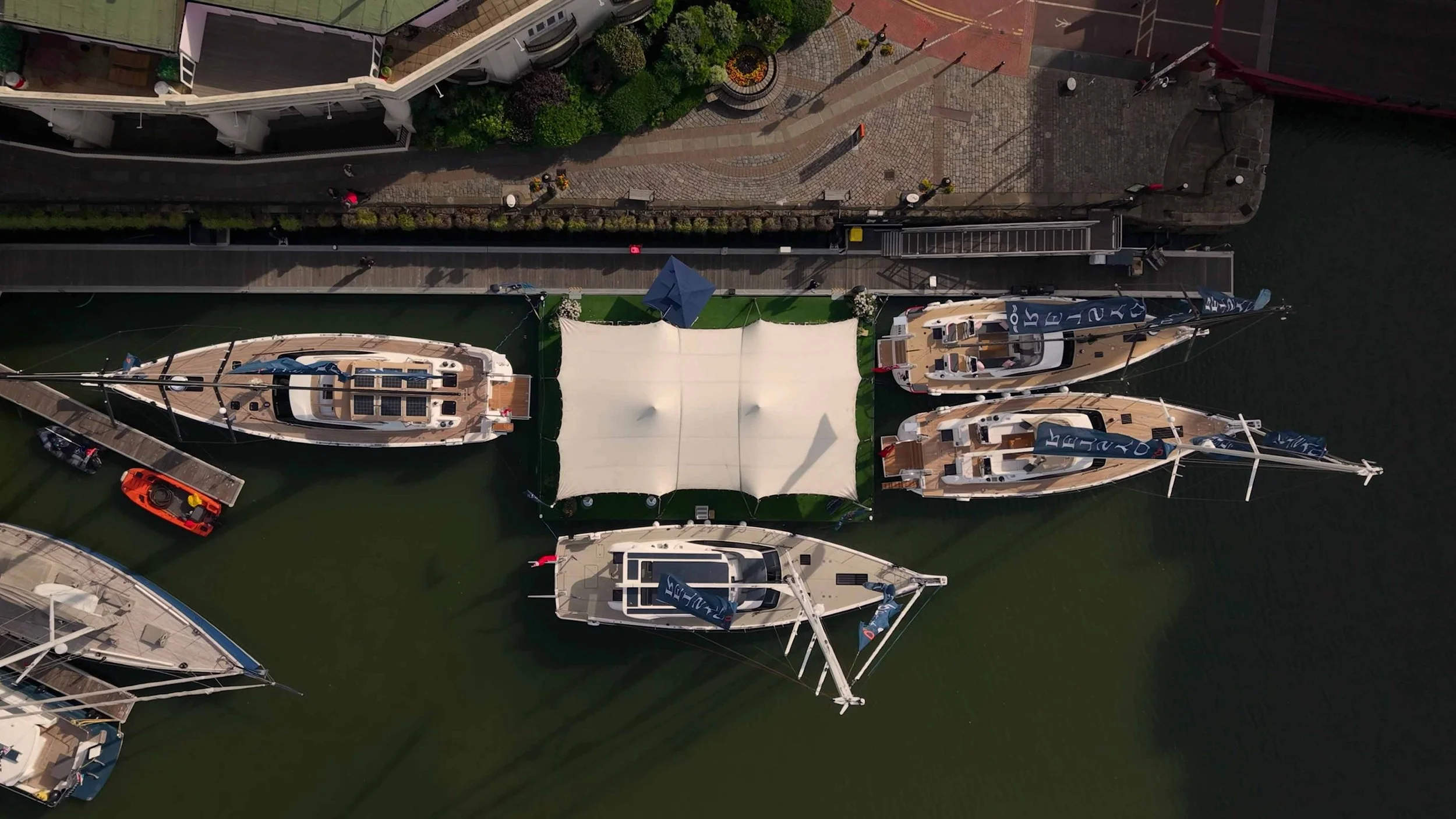 FPV drone view of Oyster Yachts at St Katharine Docks in London, showing the luxury sailing yachts, marina setting and premium waterfront display.