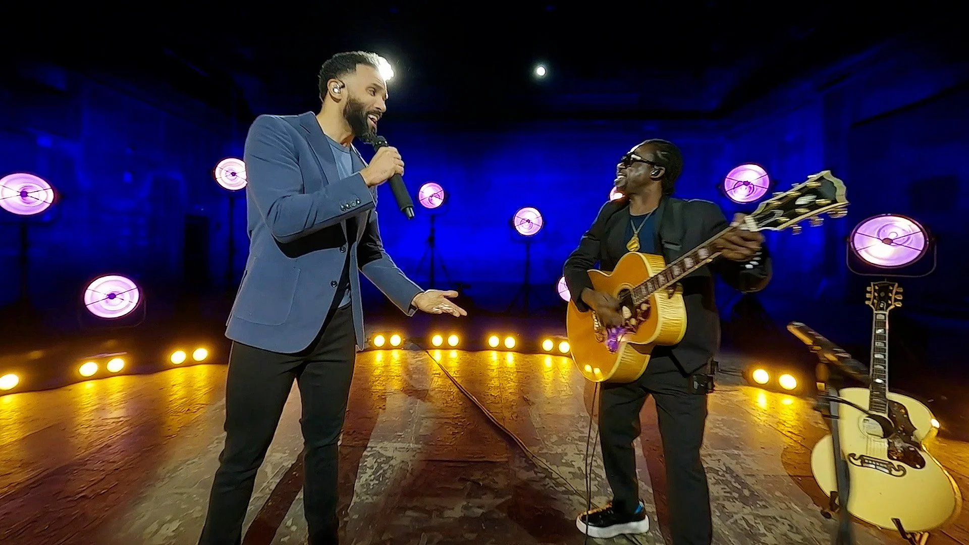 FPV drone view of Craig David performing live at Twickenham Film Studios for CNN’s New Year’s Eve broadcast, with stage lighting, production crew and performance atmosphere.