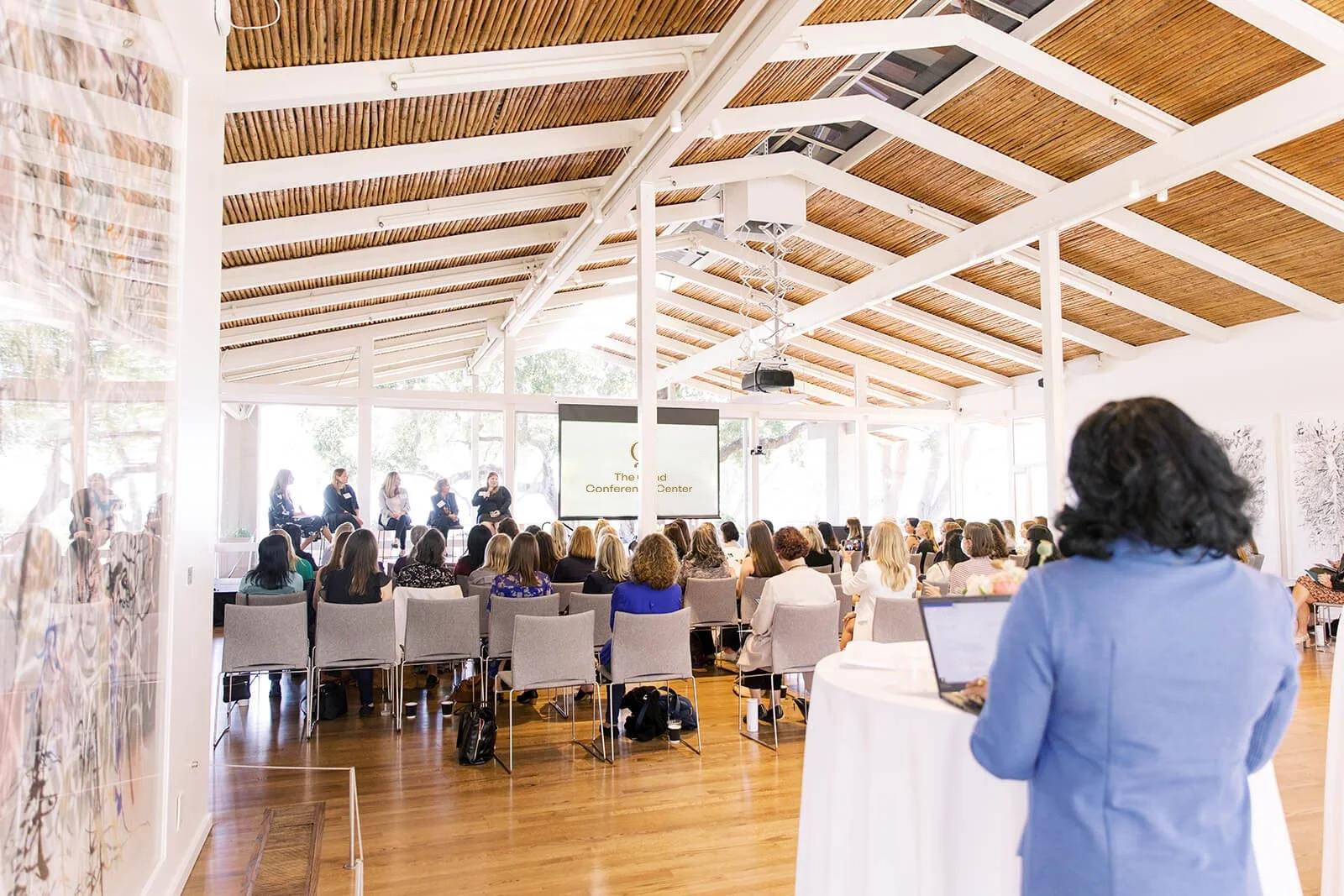 Corporate event attendees watch a presentation on the large projector screen at The Quad Conference Center.