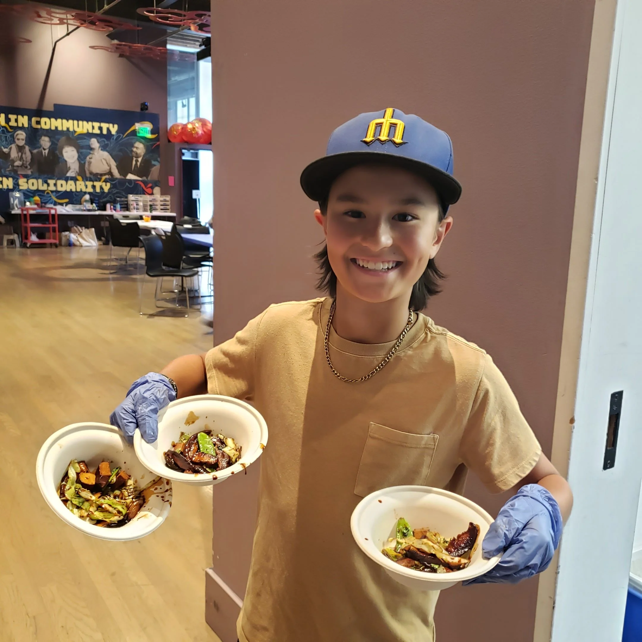 Kid smiling and holding 3 bowls of food ready serve