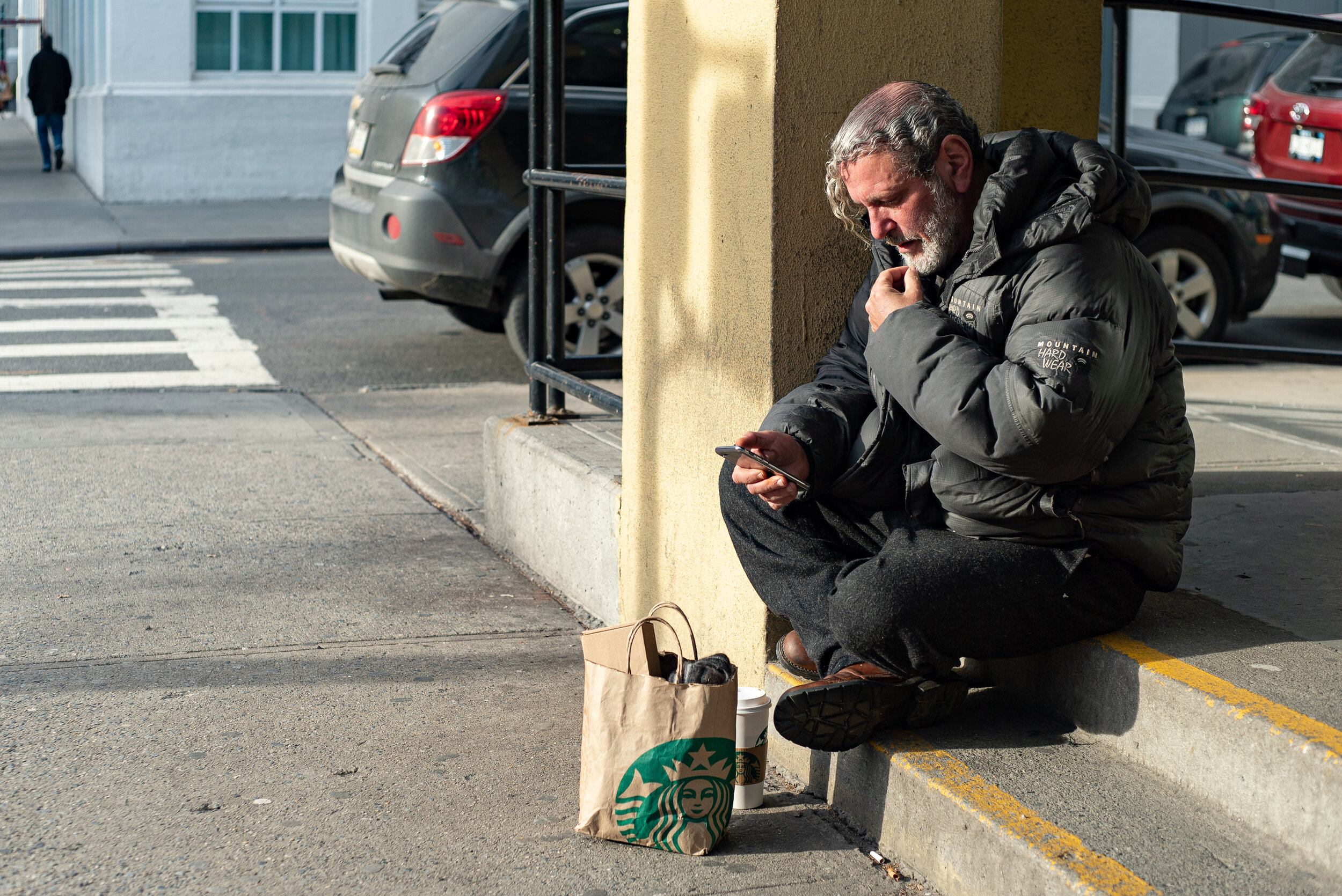 Modern day thinker uses phone in Astoria, Queens | 2018