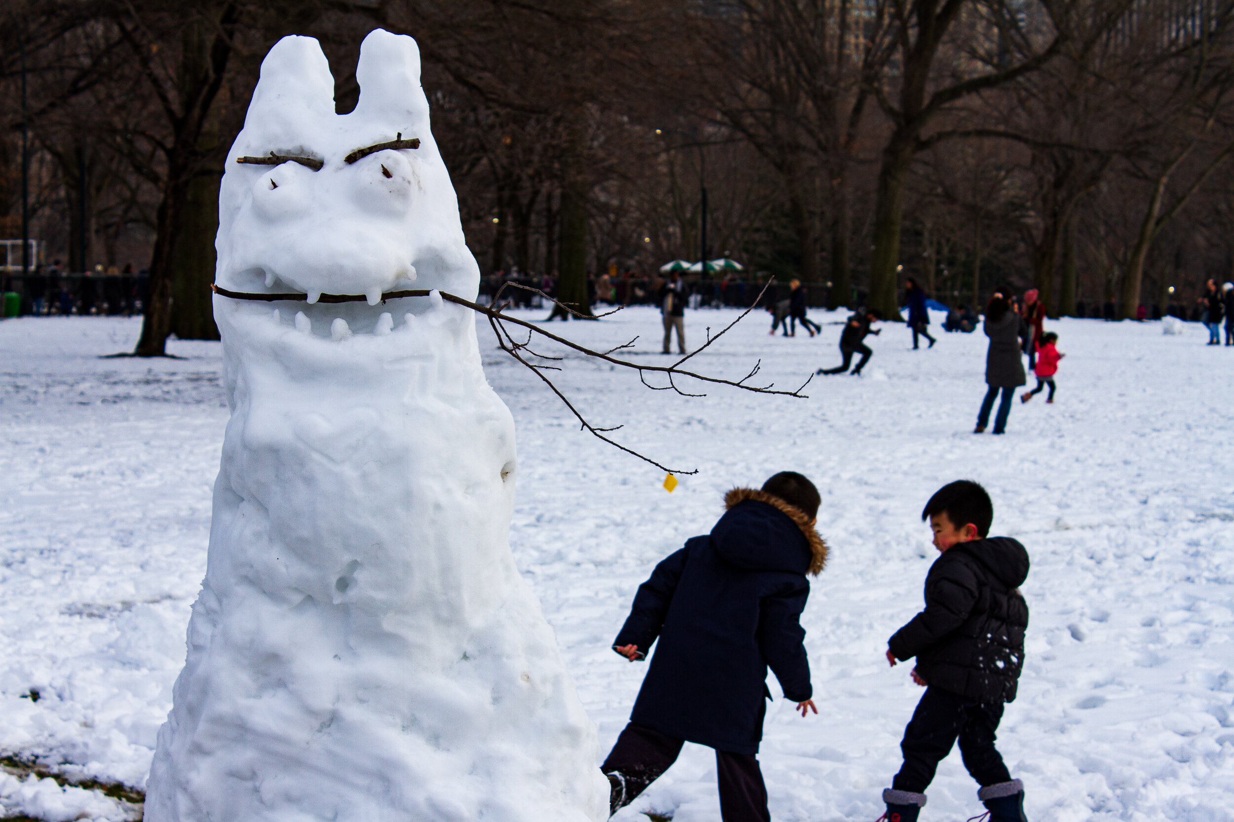Children playing in the snow behind a monster snowman | 2017