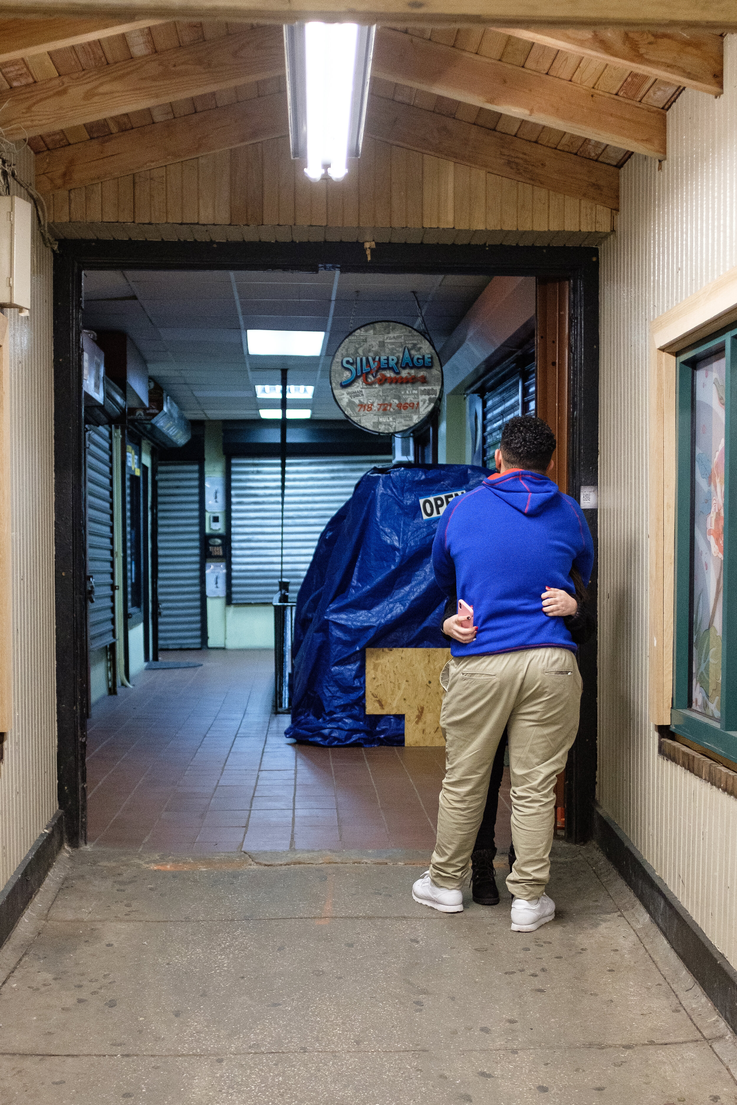 Two folks embracing in the Ditmars Avenue subway stop | 2019
