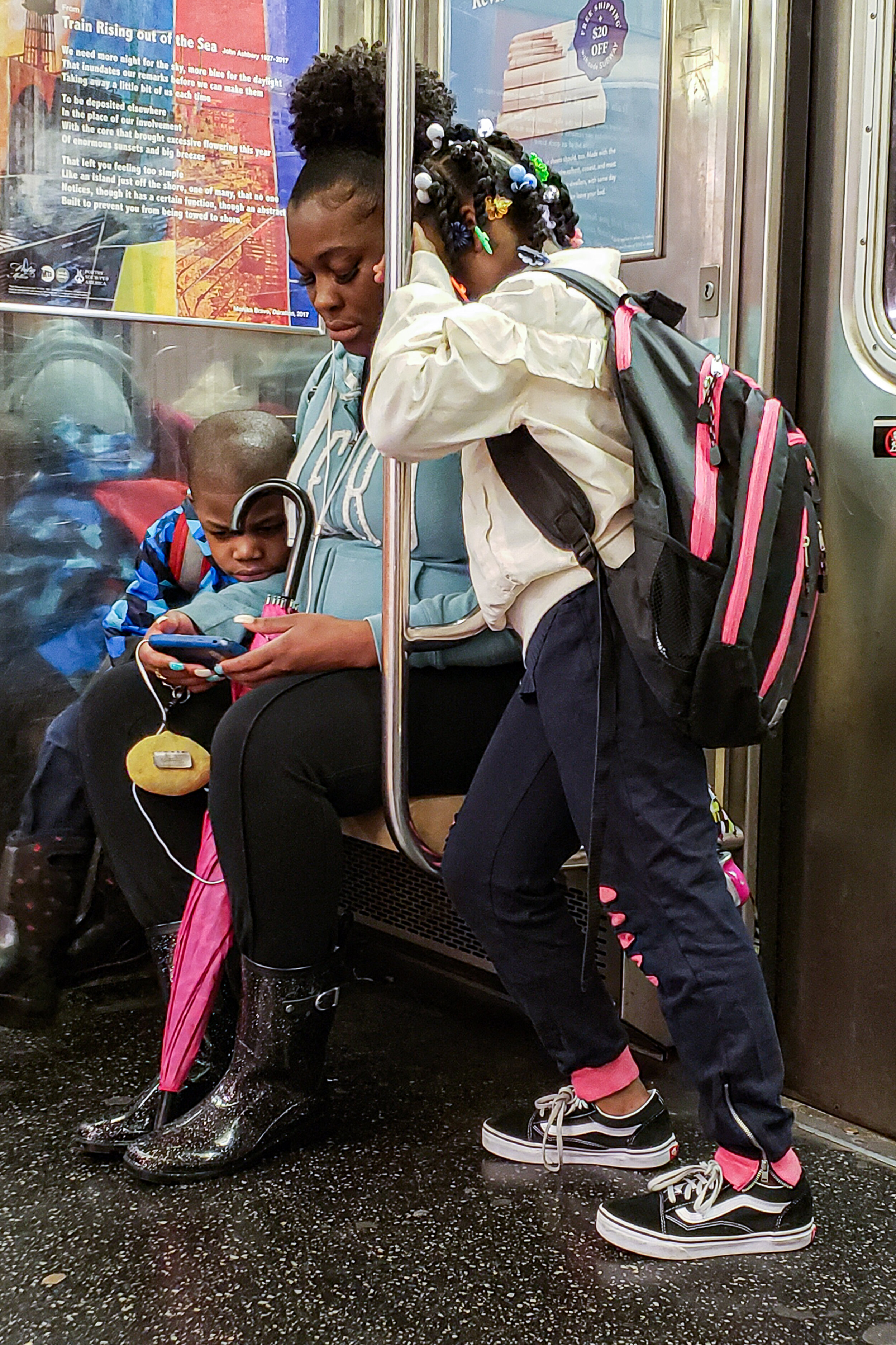 Mother shares her screen with her children on the NYC subway | 2018