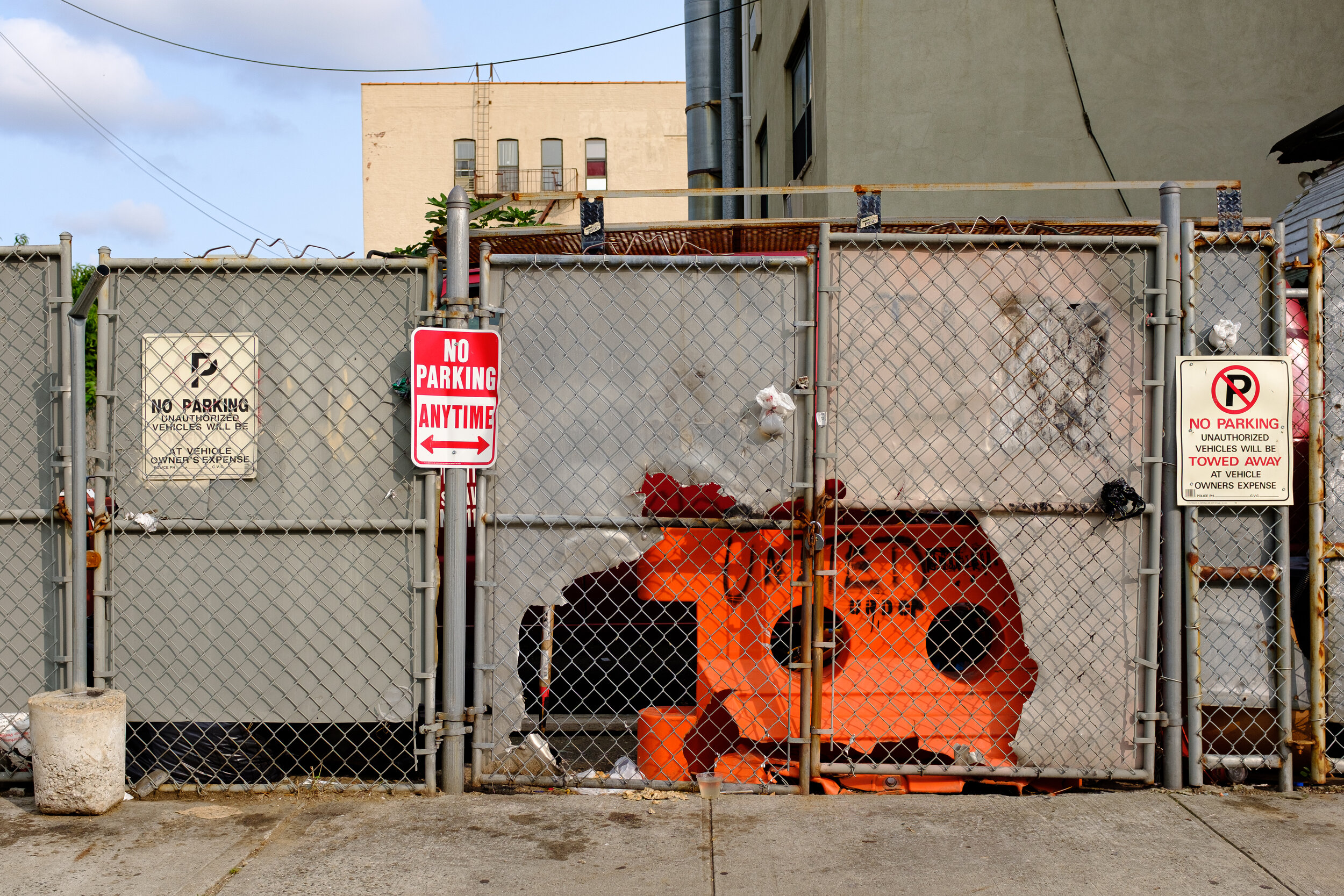 Metal fencing, sheet metal, No Parking signs and an orange divider | 2018