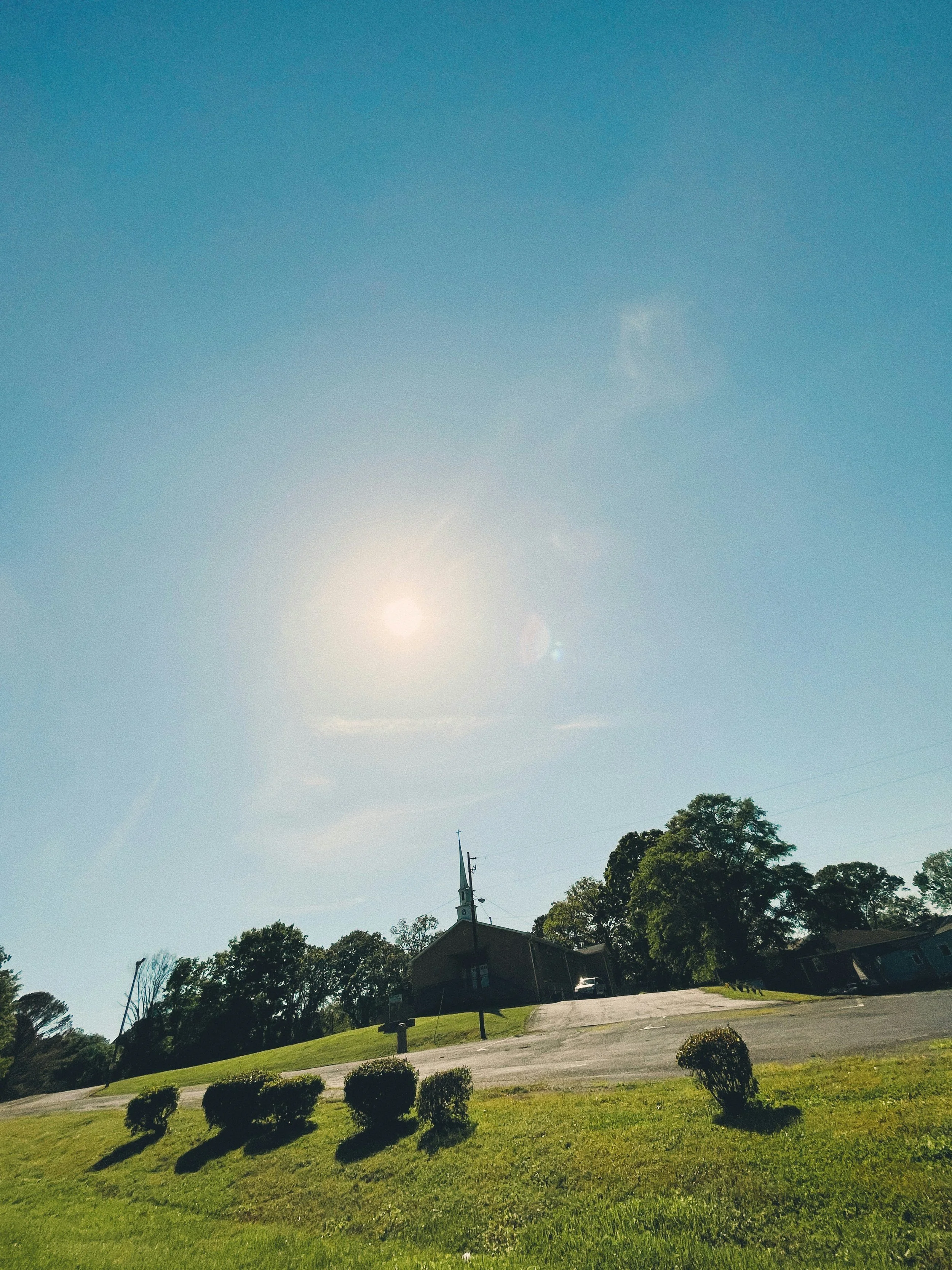 Outside a church building, sky and trees 