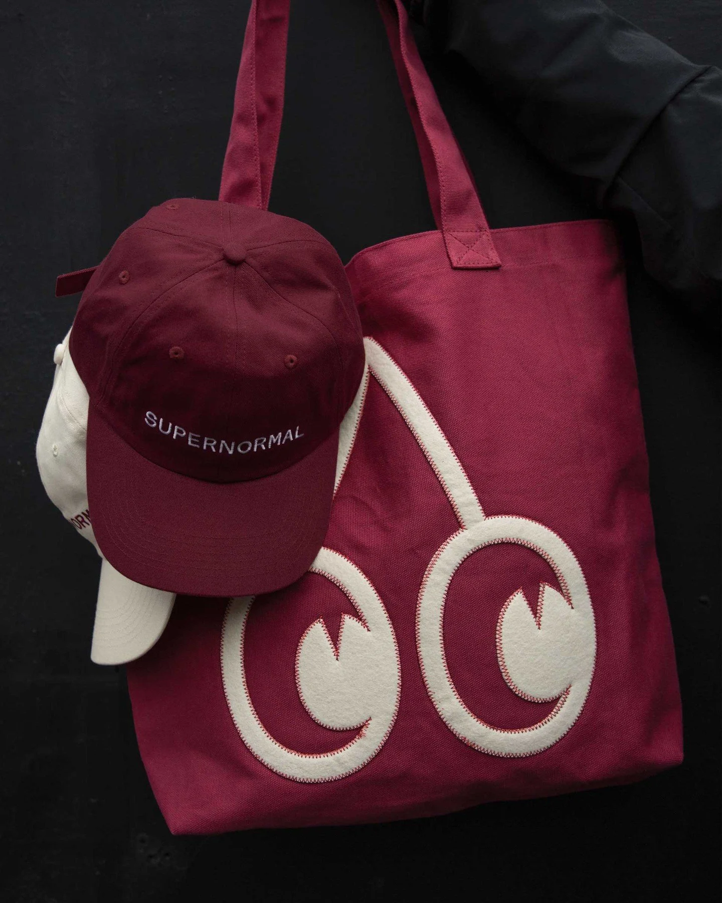 A fresh run for @supernormal_180 🍒⁠. Nine years between totes, and new hats.⁠
⁠
An update to the classic SN tote, with oversized felt appliqu&eacute;, contrast stitching and custom hardware, alongside embroidered cotton twill caps.⁠
⁠
Pumped for the