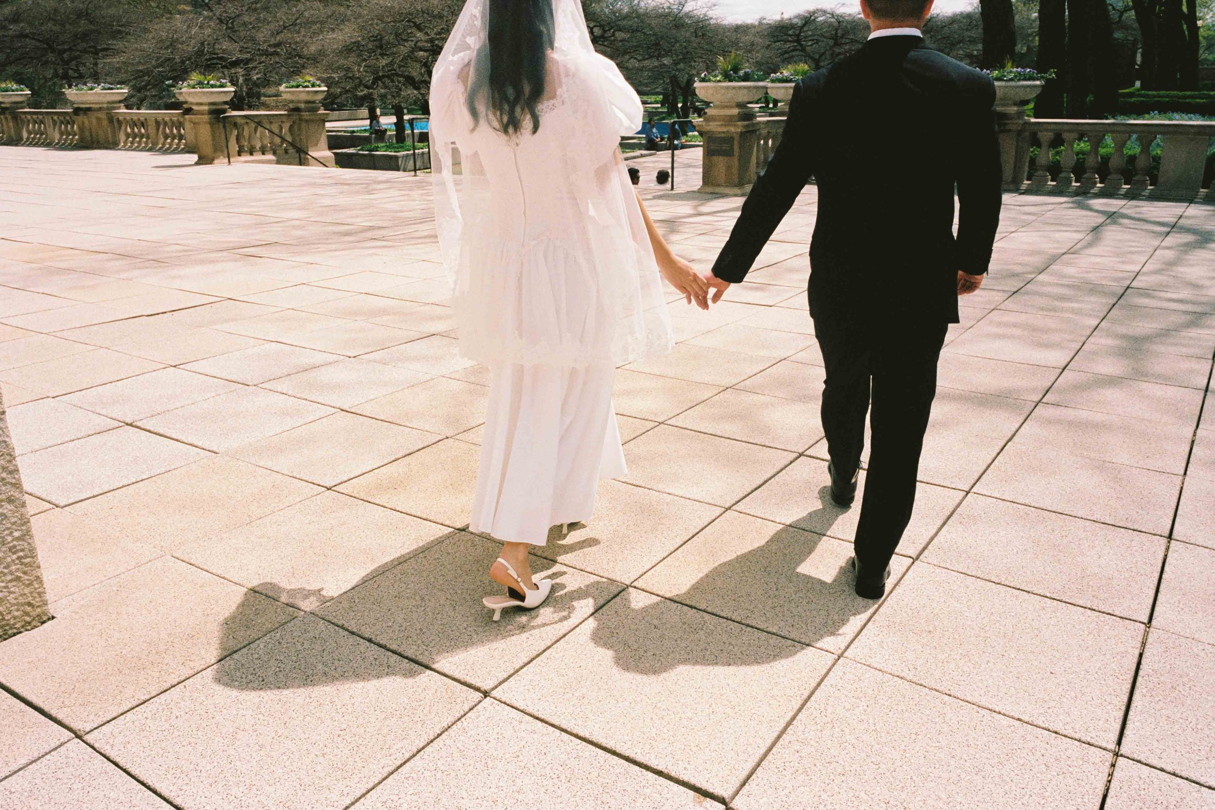 Wedding couple holding hands walking by the Chicago Art Institute
