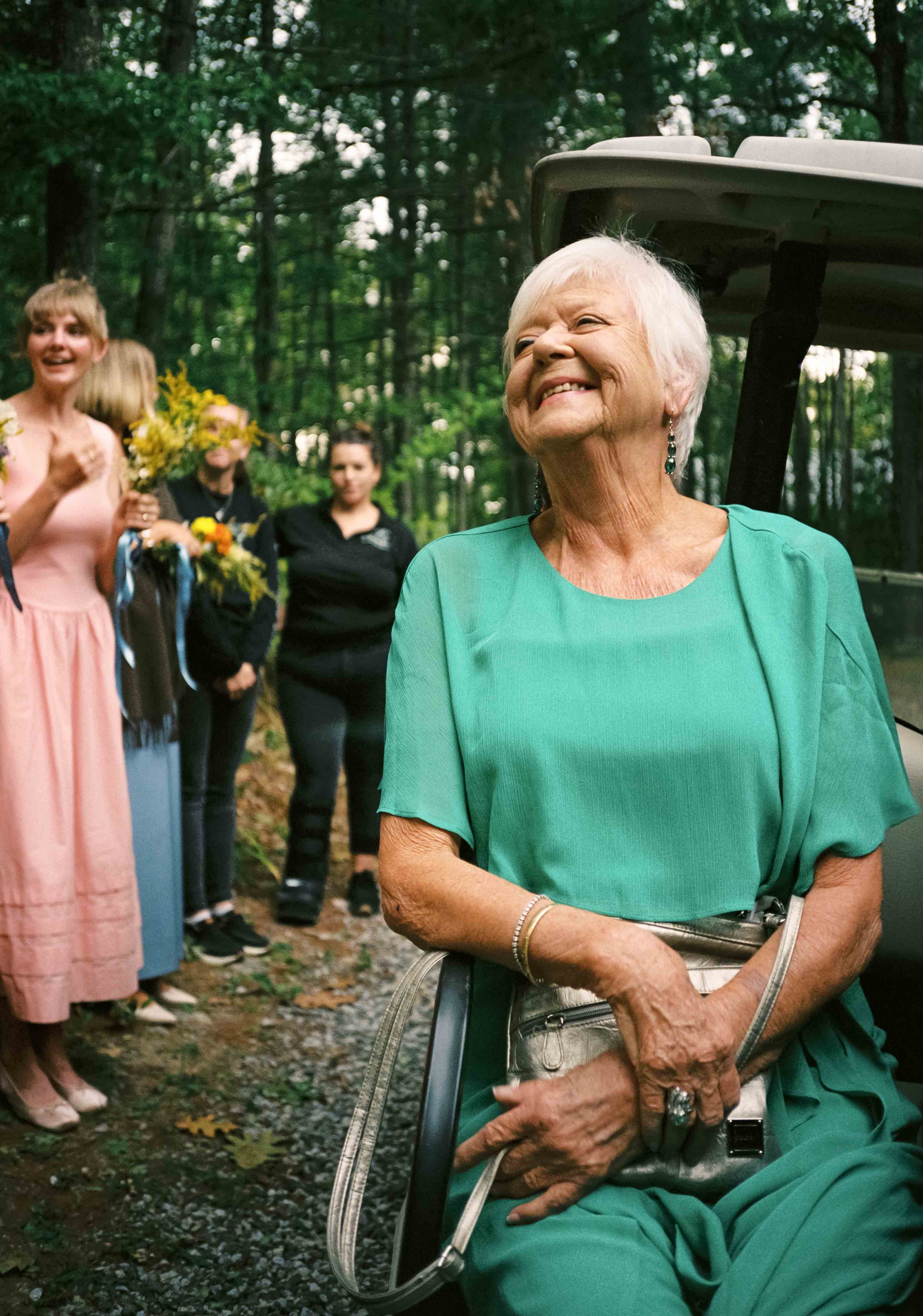 A grandma smiling very big at her grandaughter on her wedding day