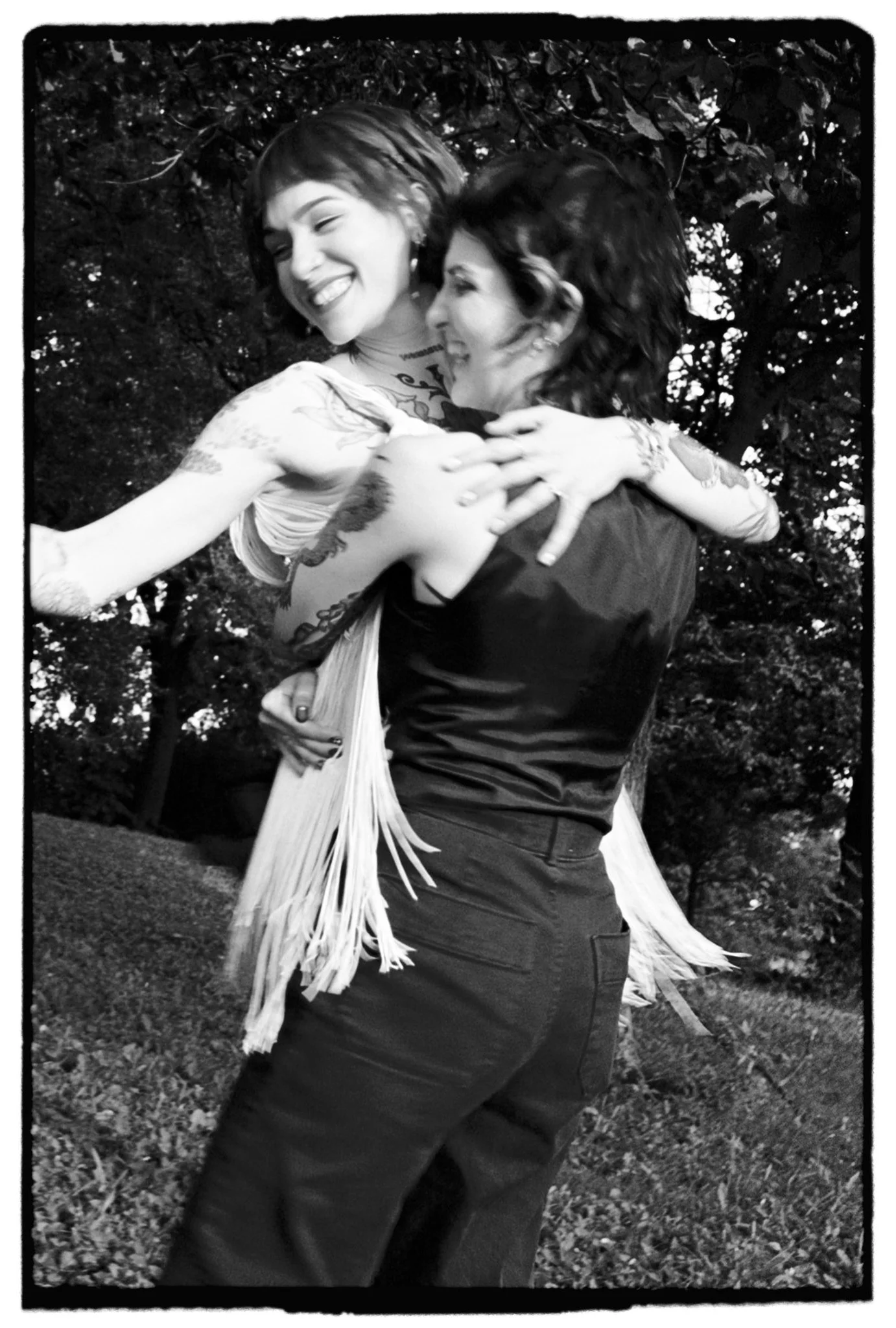 Romantic film photo of a couple twirling around and laughing