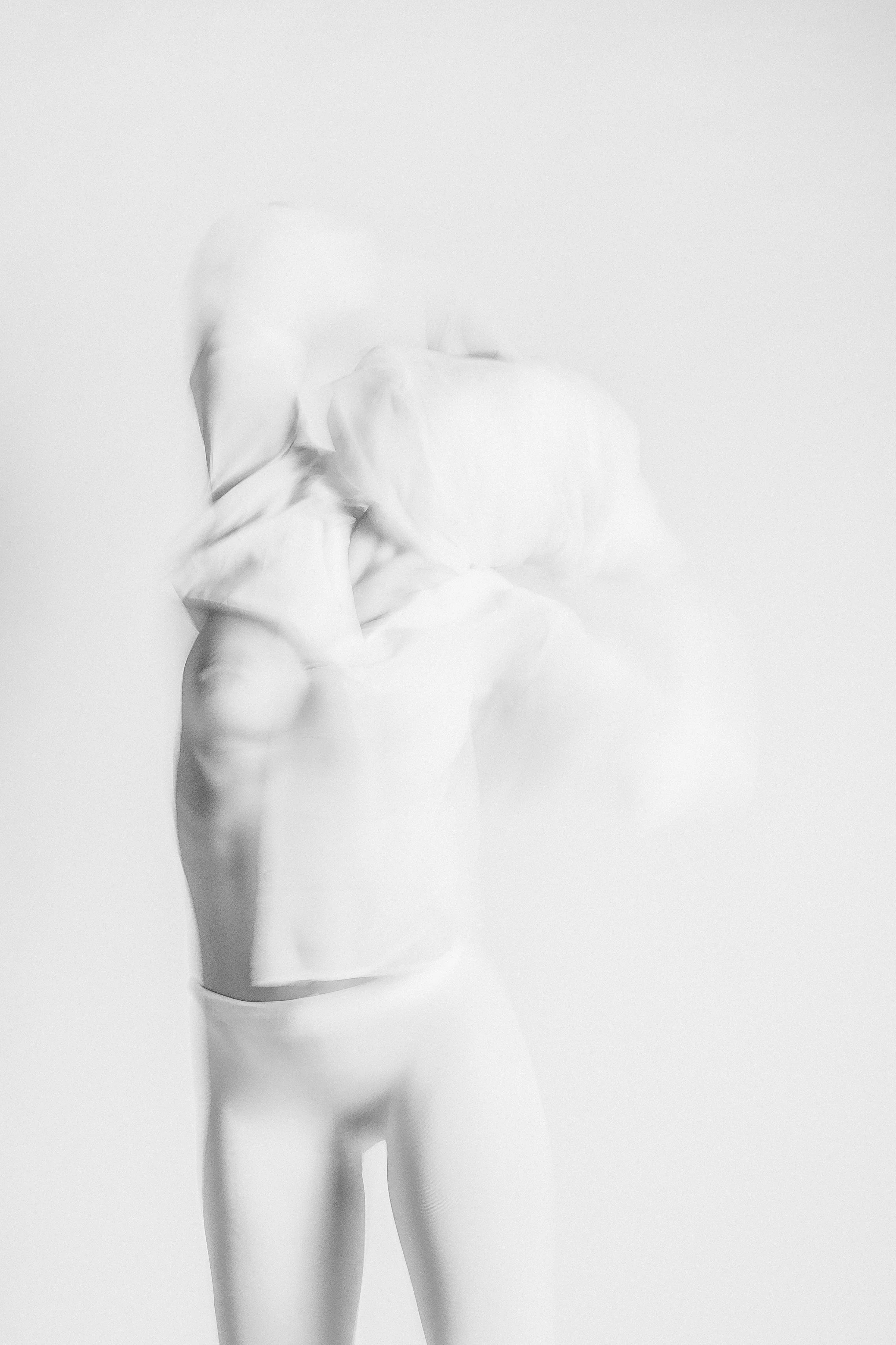 A grayscale image of a female mannequin from the waist up, dressed in a strapless dress, against a plain background.