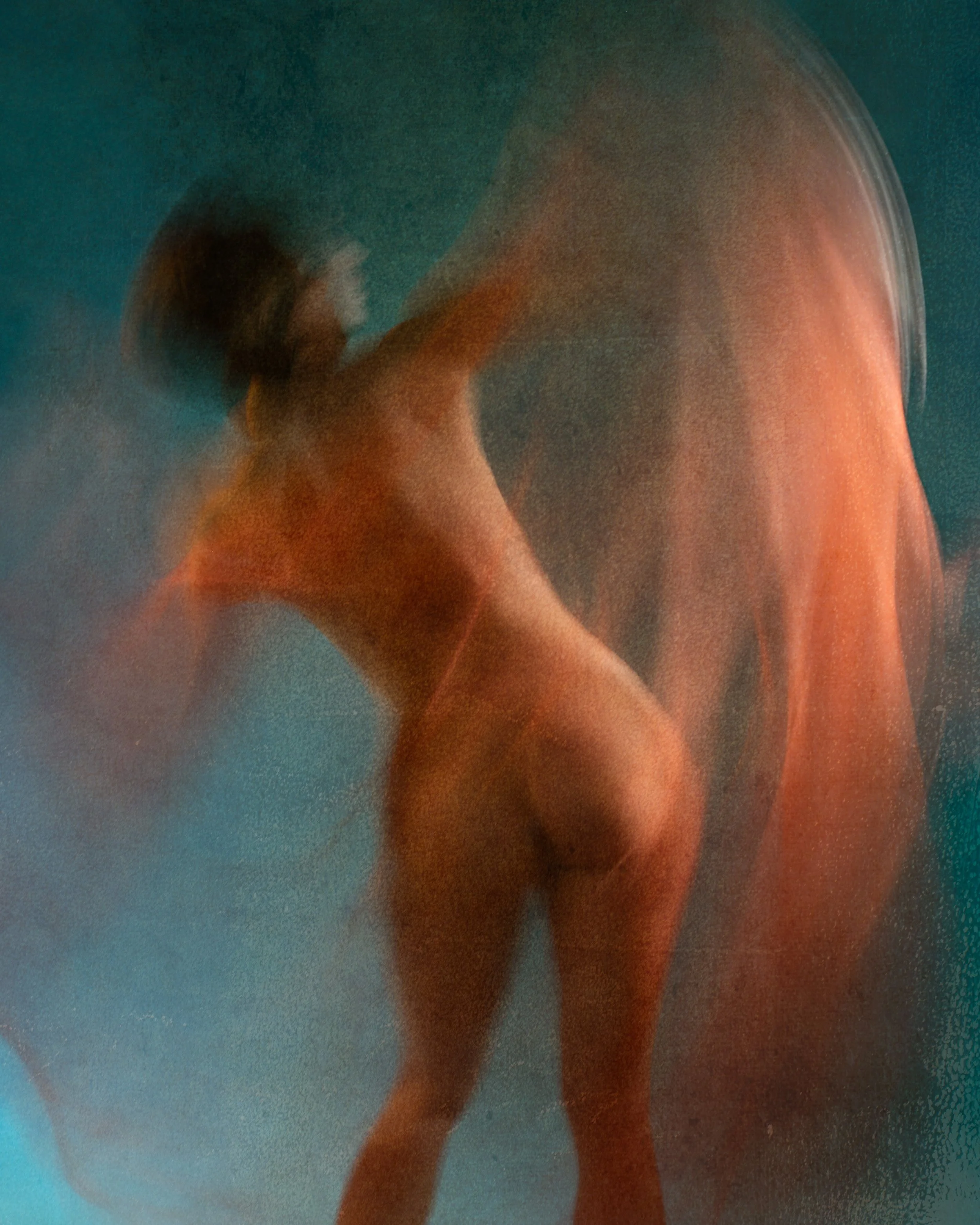 Ethereal abstract dance photo of a nude female dancer moving with orange fabric to create a painterly abstract image.