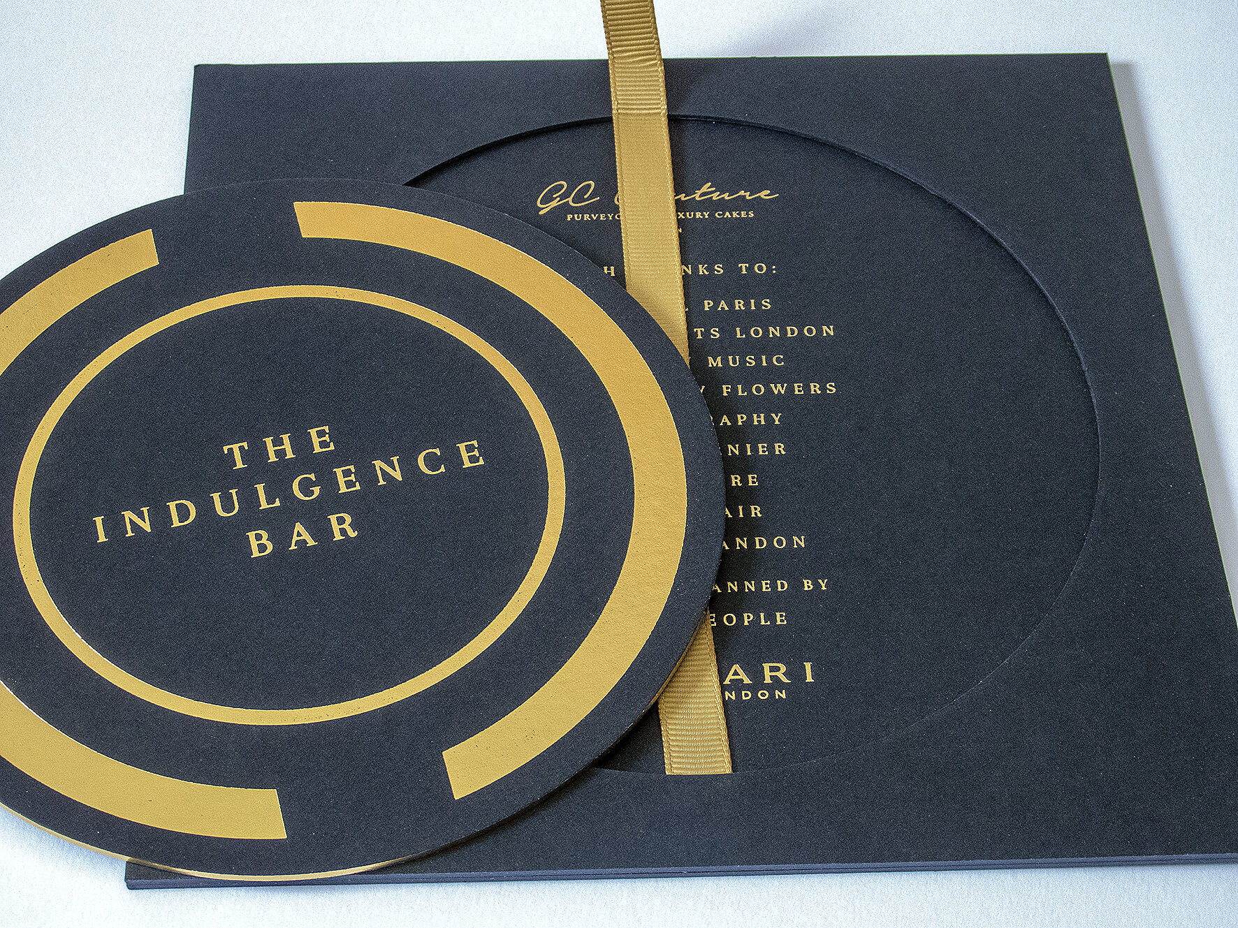 round invitation, gold foil on black, gold ribbon, chunky invite