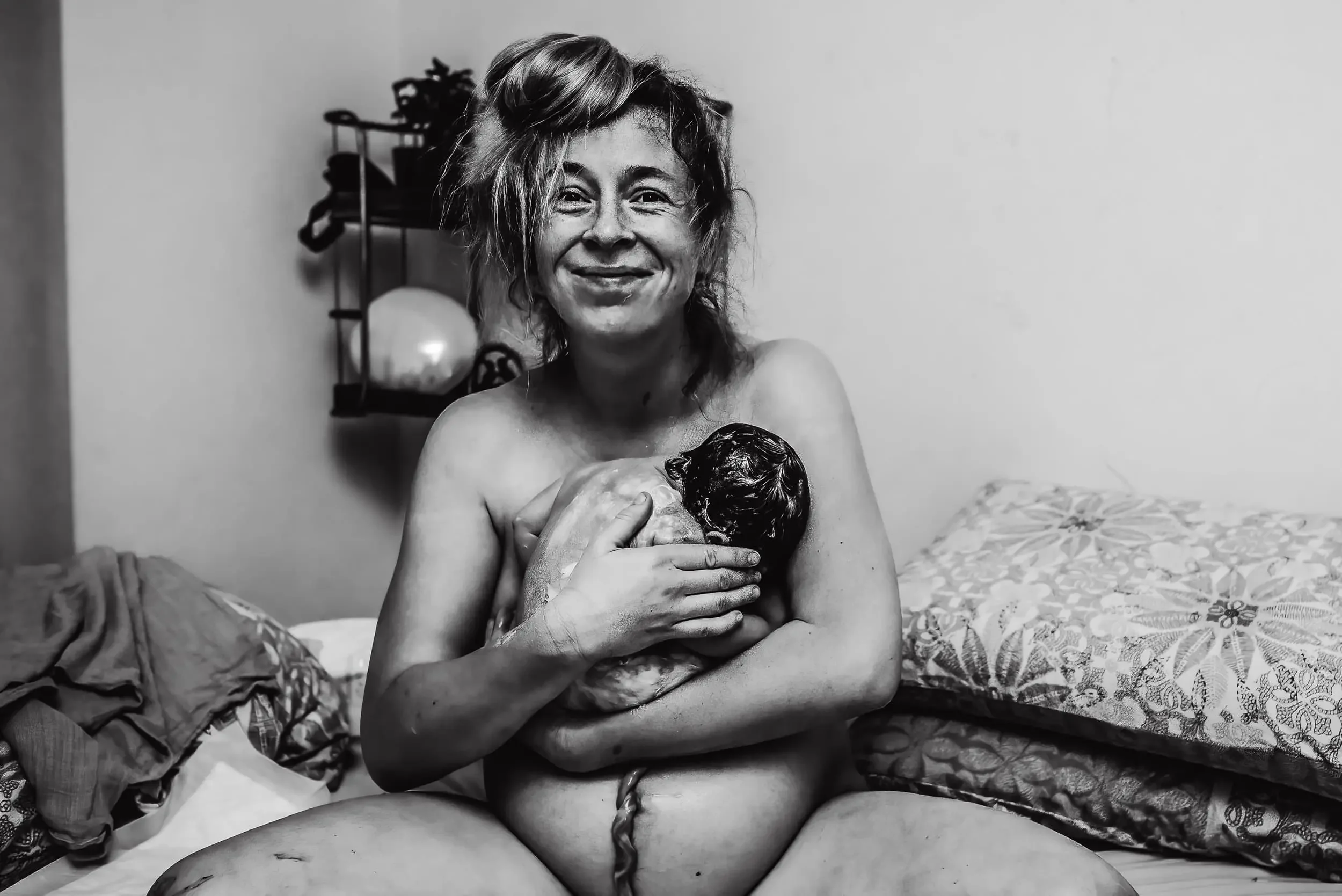 A woman holding her newborn baby in her arms after a homebirth in Amsterdam