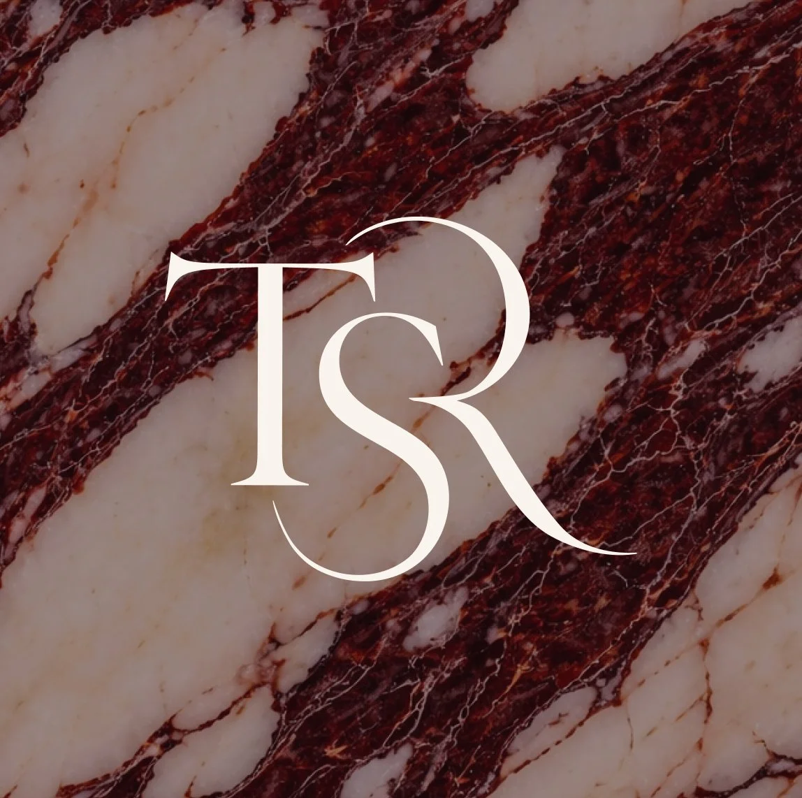 Close-up of a marble surface with dark red and white veining, overlaid with a white logo consisting of the letters 'T', 'S', and 'R' in a decorative font.
