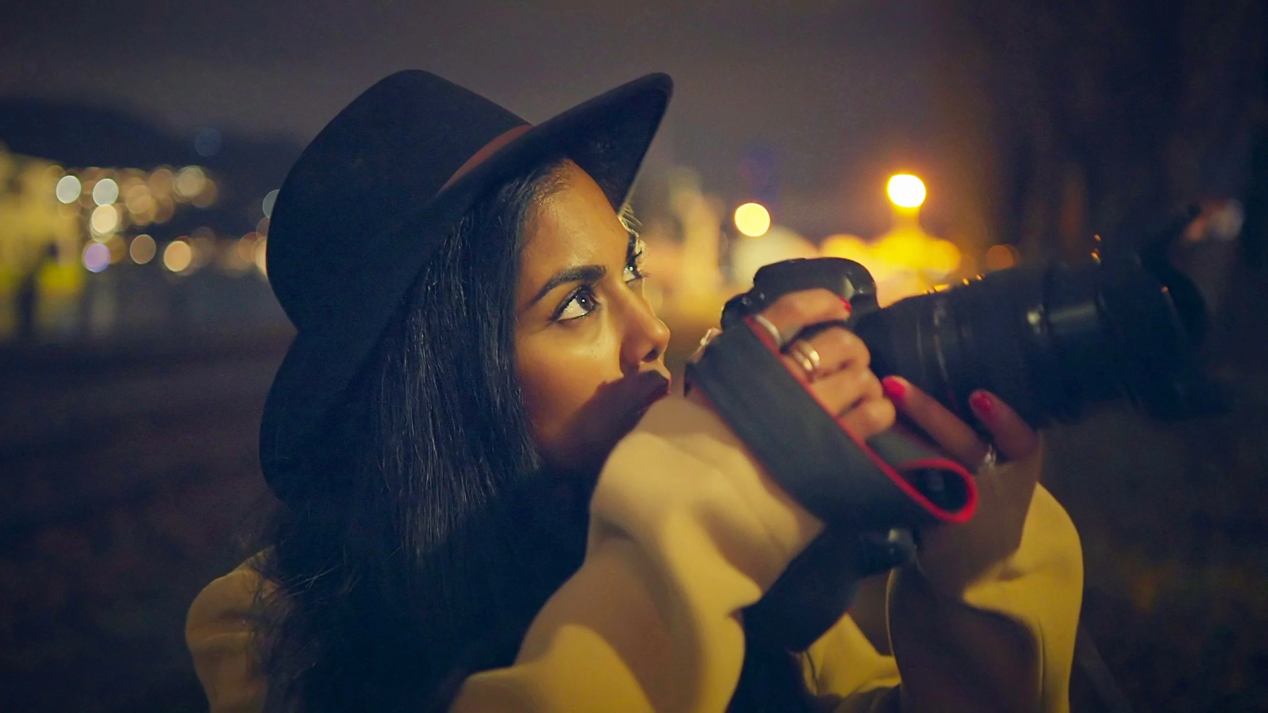 lifestyle-portrait-of-stylish-young-woman-wearing-a-hat-holding-camera-SBI-349537005.jpg
