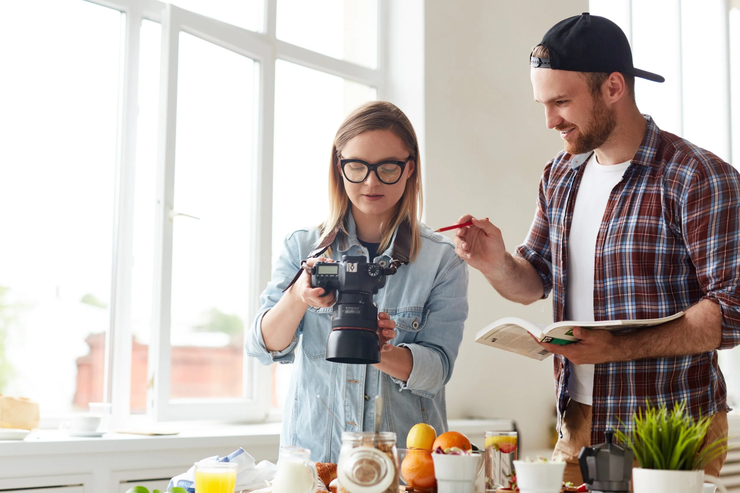 skilled-photographers-discussing-shots-of-food-at-meeting-SBI-325331488.jpg