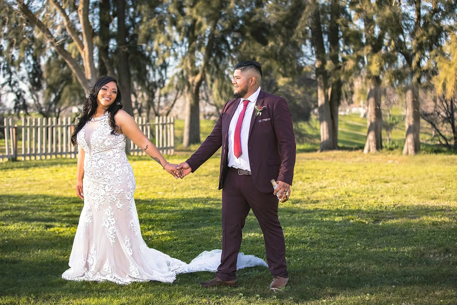 Bride and groom holding hands and smiling during an outdoor wedding portrait at Gibson Ranch Park.