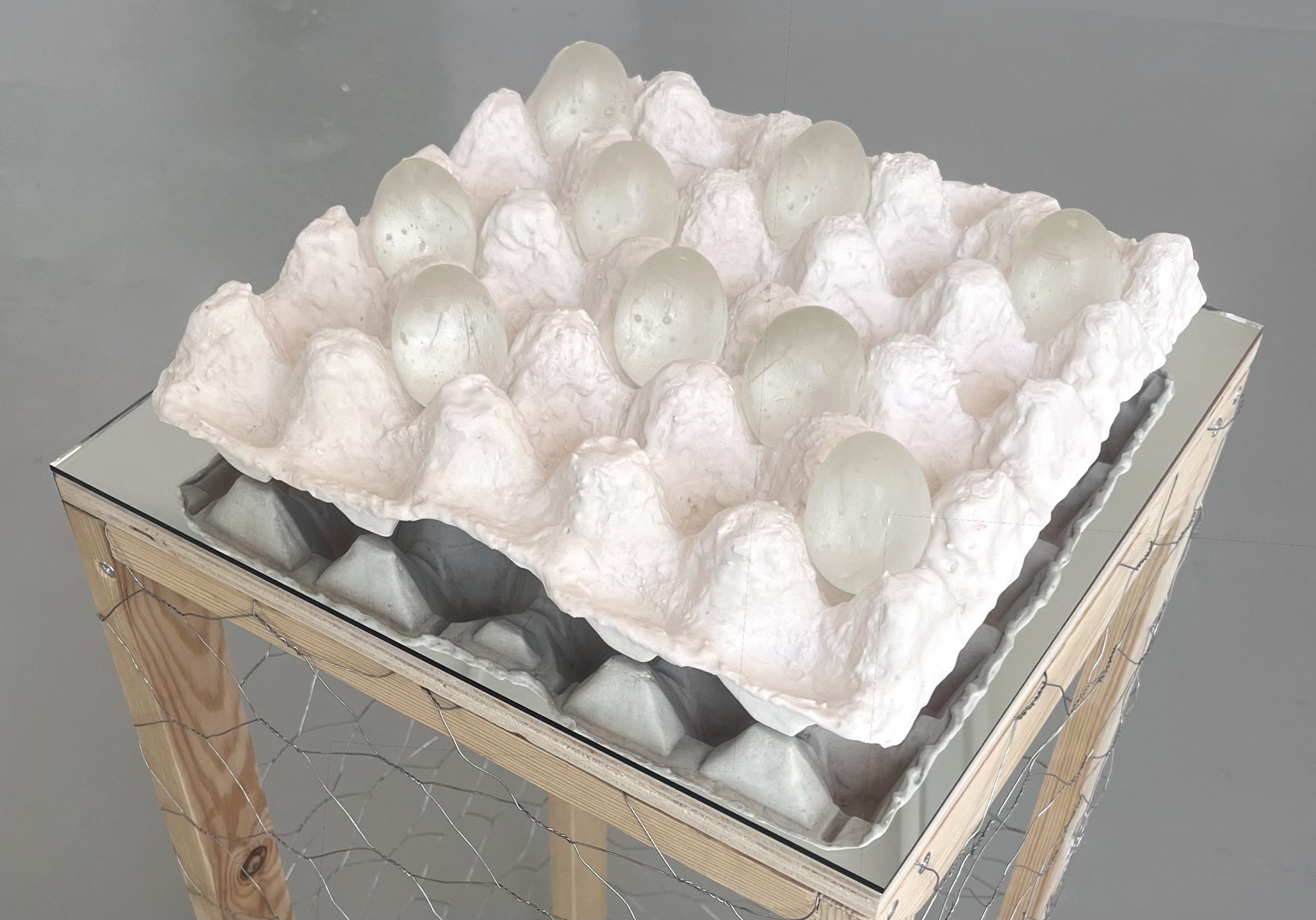Untitled (Jesmonite Carton with Glass), 2025–2026
Cast Jesmonite, cast glass, mirror, and wire cage.  
Carton: 9 x 30 x 30 cm. Plinth: 90 x 34 x 34 cm.