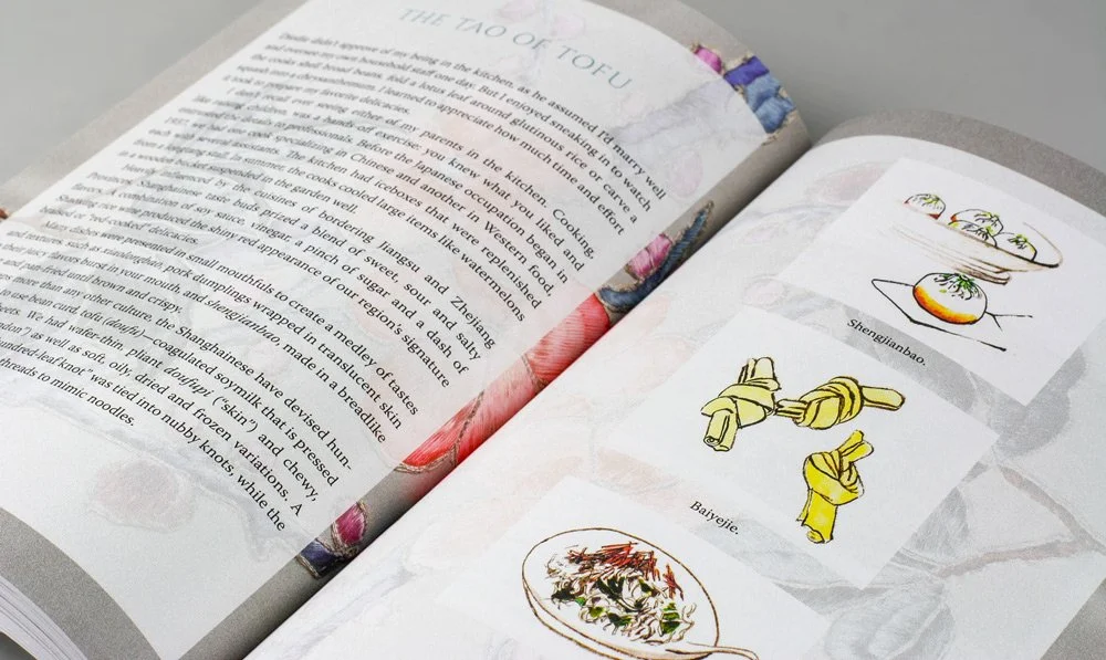 A close up shot of a spread from Remembering Shanghai, featuring colorful page borders and illustrations