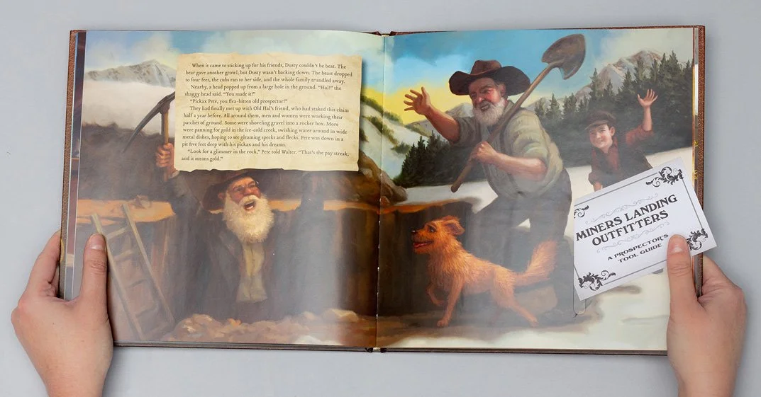 The Great Gold Rush Adventure, an interactive children's book, is opened by a pair of hands