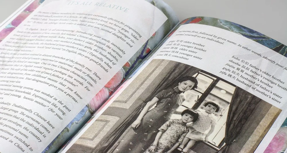 A close-up of a spread from Claire Chao's book, Remembering Shanghai, with colorful, floral-patterned page borders and a sepia-toned family portrait of a woman and two children