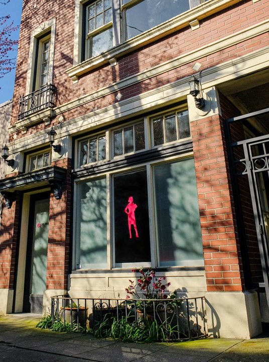 The front of a brick building with the Girl Friday Productions logo in the window