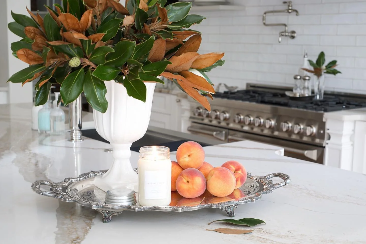 Something I miss about Georgia&hellip; those delish peaches 🍑 paired with that @antiquecandleco_ 
 flame, magnolia branches from the yard and pretty silver platter&hellip; That island felt sooo southern! Ha🤍 Happy peach season!