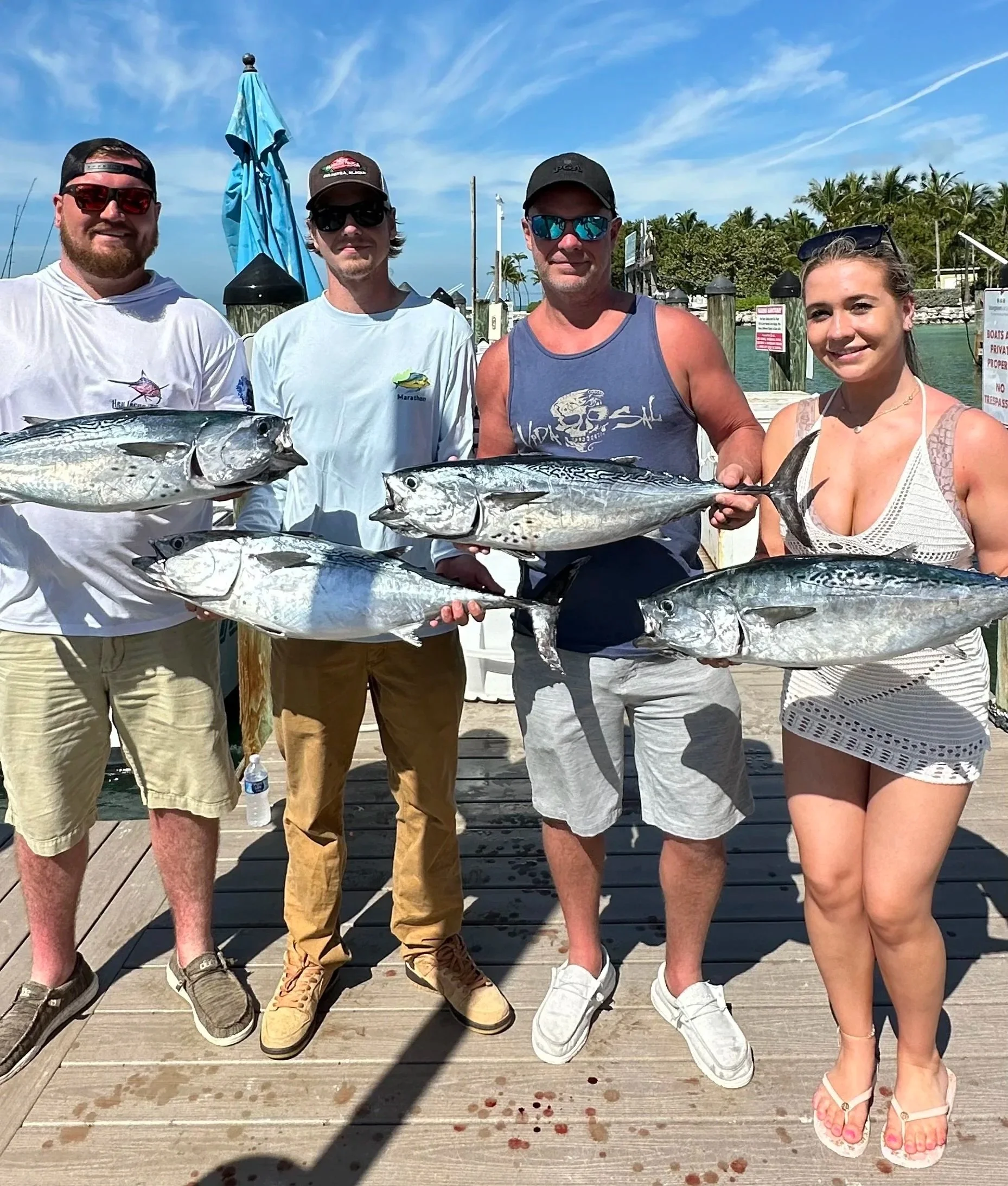 Family of 4 holding up tunas after a successful day offshore!