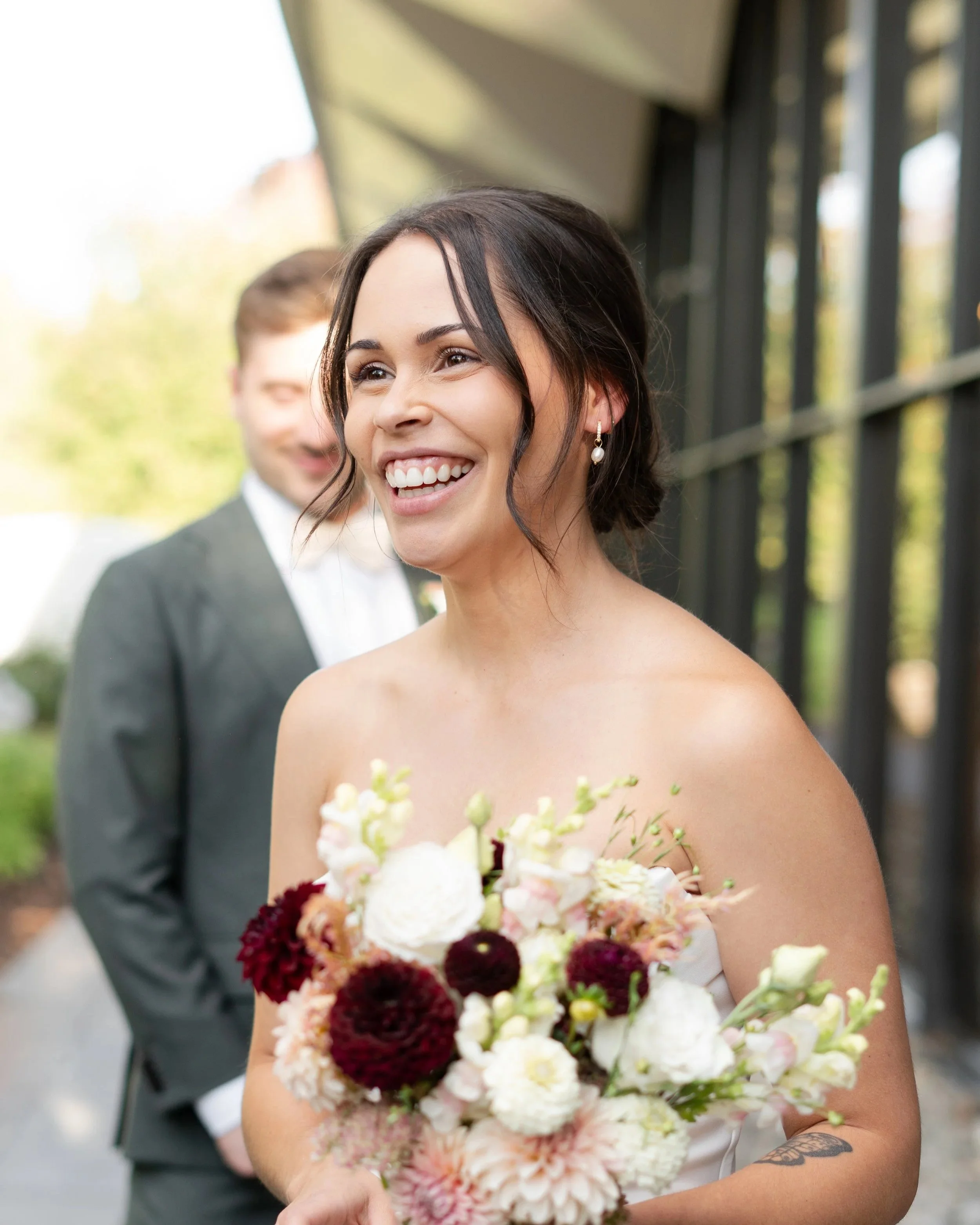 Candid of a bride holding a bouquet of flowers, smiling happily. La Toundra, Montreal.
