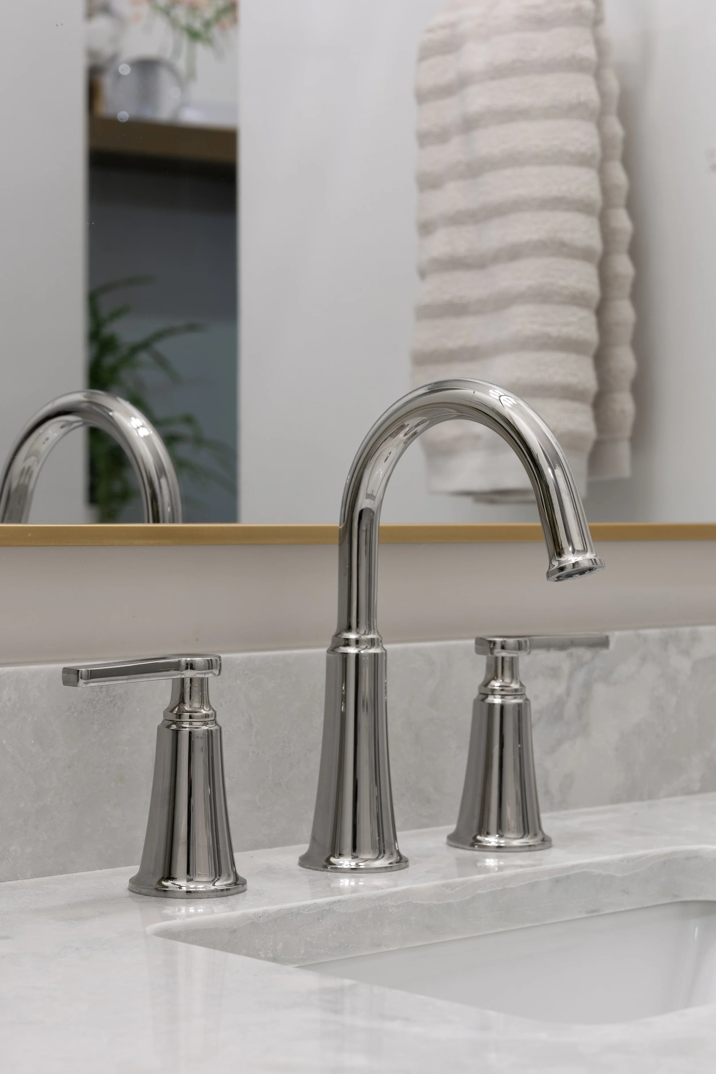 Riobel’s Momenti polished nickel bathroom sink faucet with two handles for hot and cold. The faucet is arc'd with a nice curve.