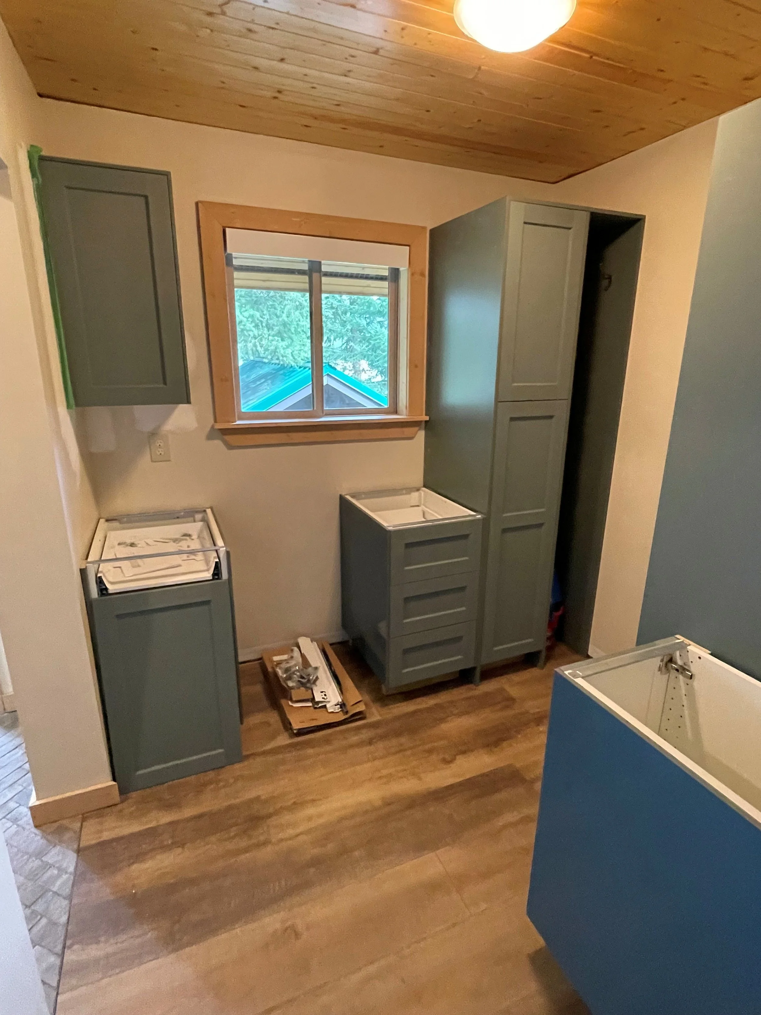 IKEA green cover panels and customized green doors use a Hyundai Bodaq Painted Wood Muddy Green wood architectural film. Used on lower cabinets and tall pantry.