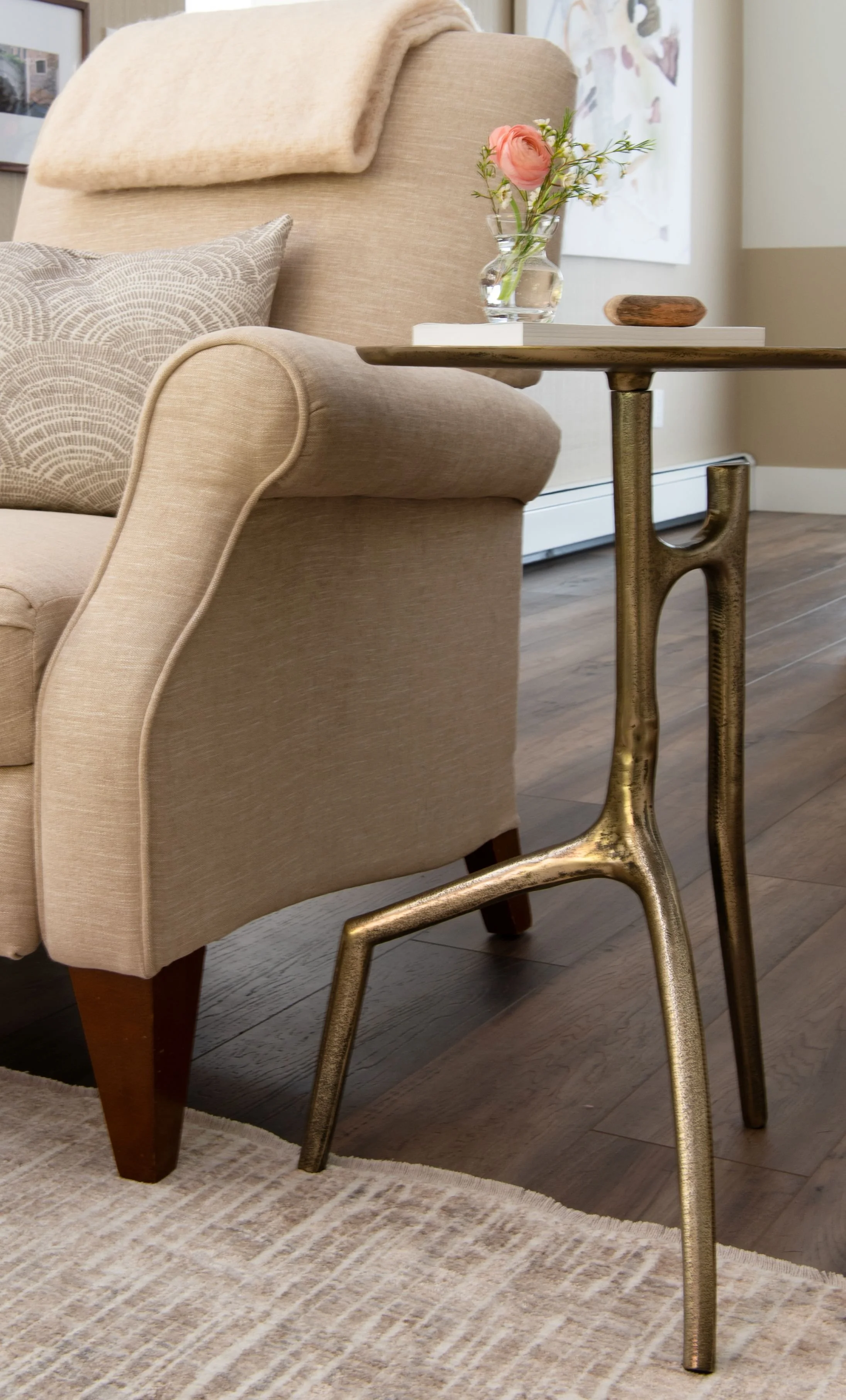 A gold side table, weathered and relaxed, but still elegant because of the fine structure of the legs, this elegant side table sits next to a newly upholstered reclining chair in a soft beige chenille fabric called Downie Wheat Kings from Van Gogh.