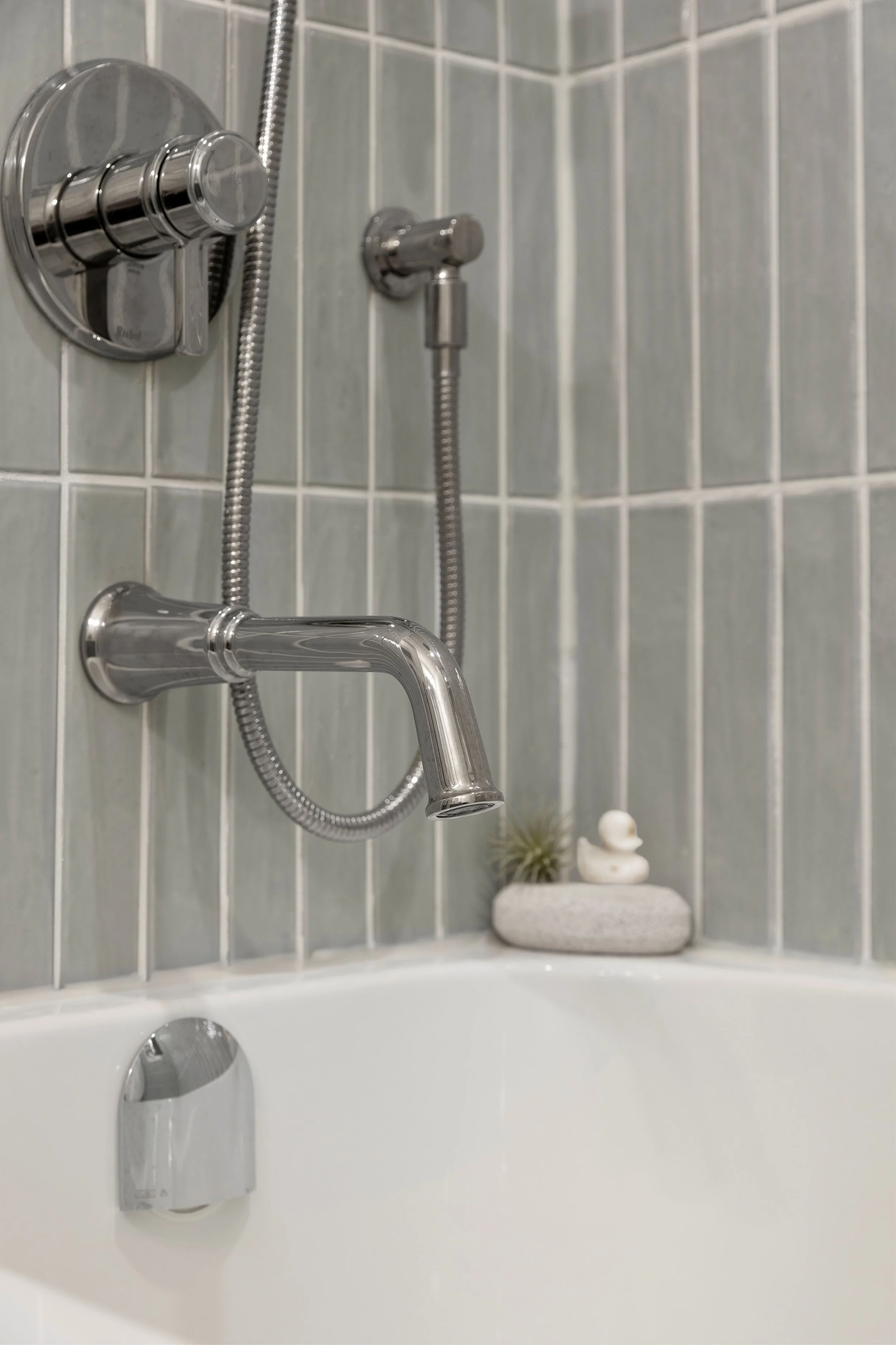 Gorgeous House of Rohl Riobel Momenti Polished Nickel tub spout and shower kit. Elegant and sophisticated fixtures in an updated bathroom. White rubber duckie soap reminds the viewer to not be too serious. Relax, have a bath.