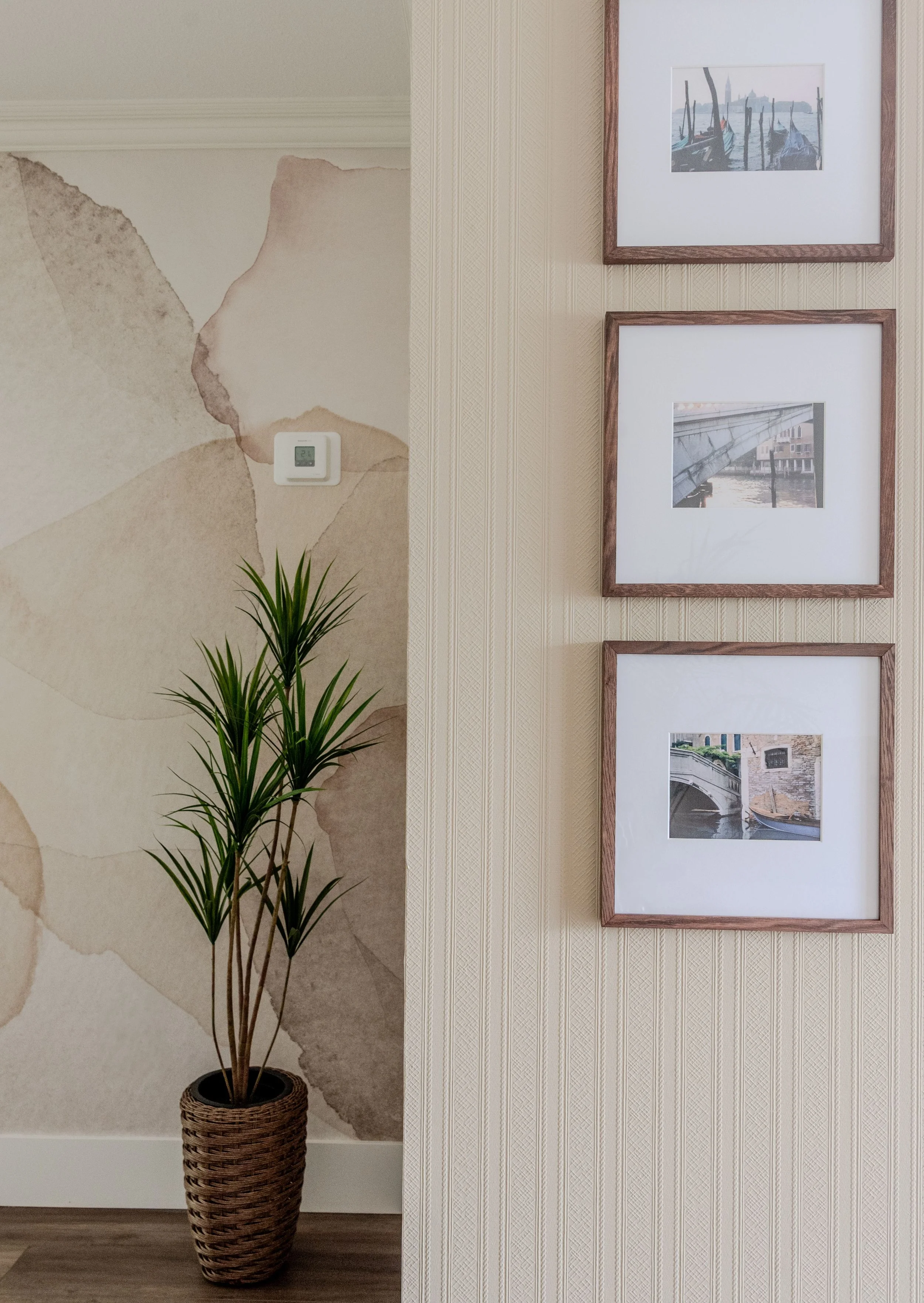 Rebel Wall "Petals" wallpaper in Sand colorway is on the back wall, while the wall in the foreground has old stripe textured wallpaper that has been painted in a color found in the wallpaper, to help this dated wall become updated and cohesive.