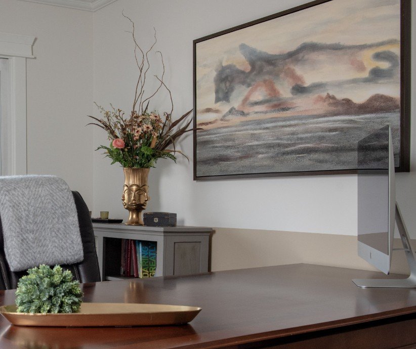 New large artwork in an office area over a desk to help balance the desk in the space. Art image features a volcano type mountain in a vast dark blue sea. Art by Renwil.
