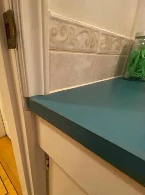 DIY gone bad in the bathroom. The bathroom counter wouldn't fit so the solution was to cut the door casing instead of getting a smaller vanity unit! It looks ridiculous and is good for a chuckle. Bad renovation DIY.