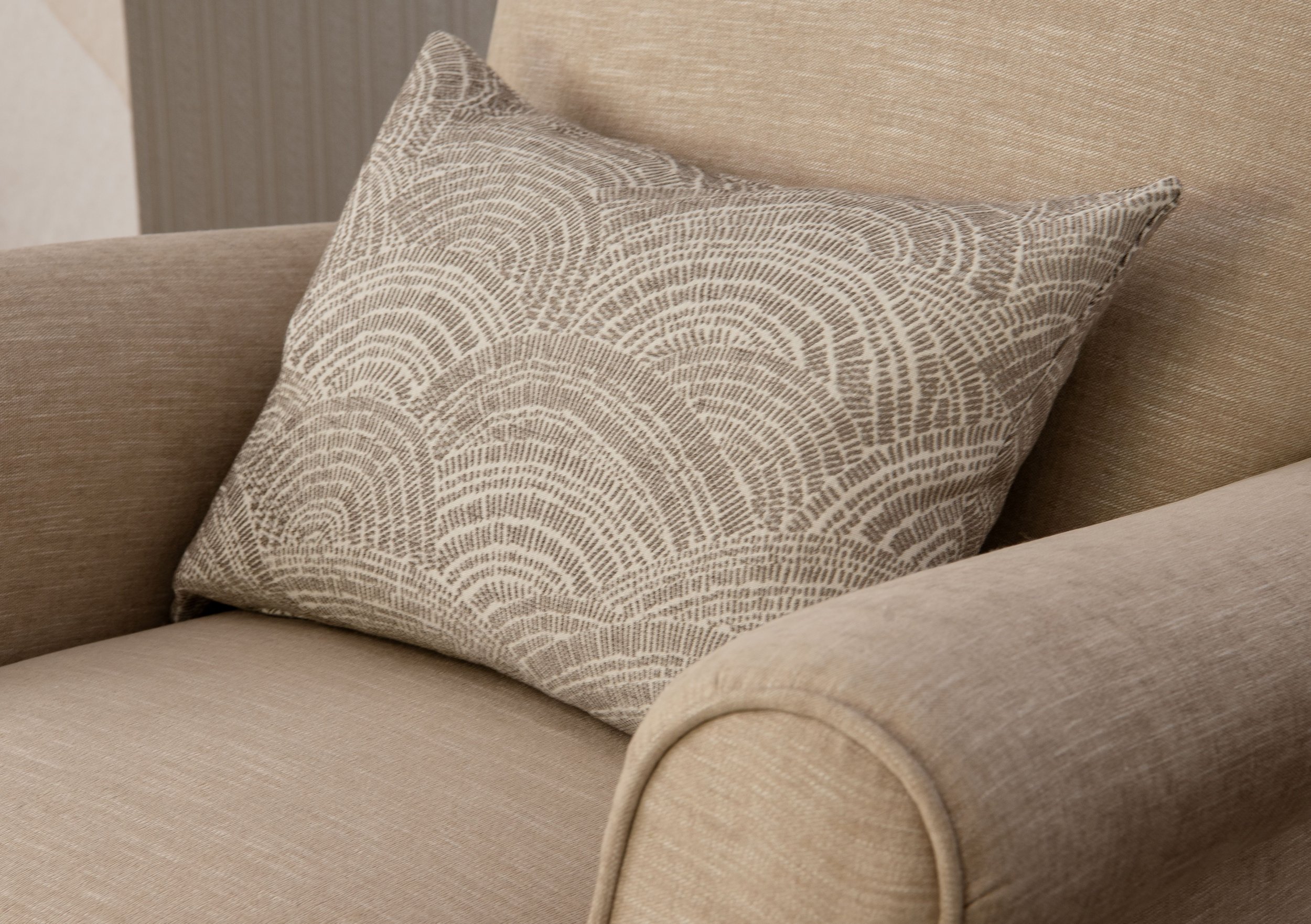 Reupholstered recliner chair in a soft neutral colored fabric of soft beige. Accent pillow fits on the chair neutral in grey and white patterned color by Maxwell Fabric in Pepperland.