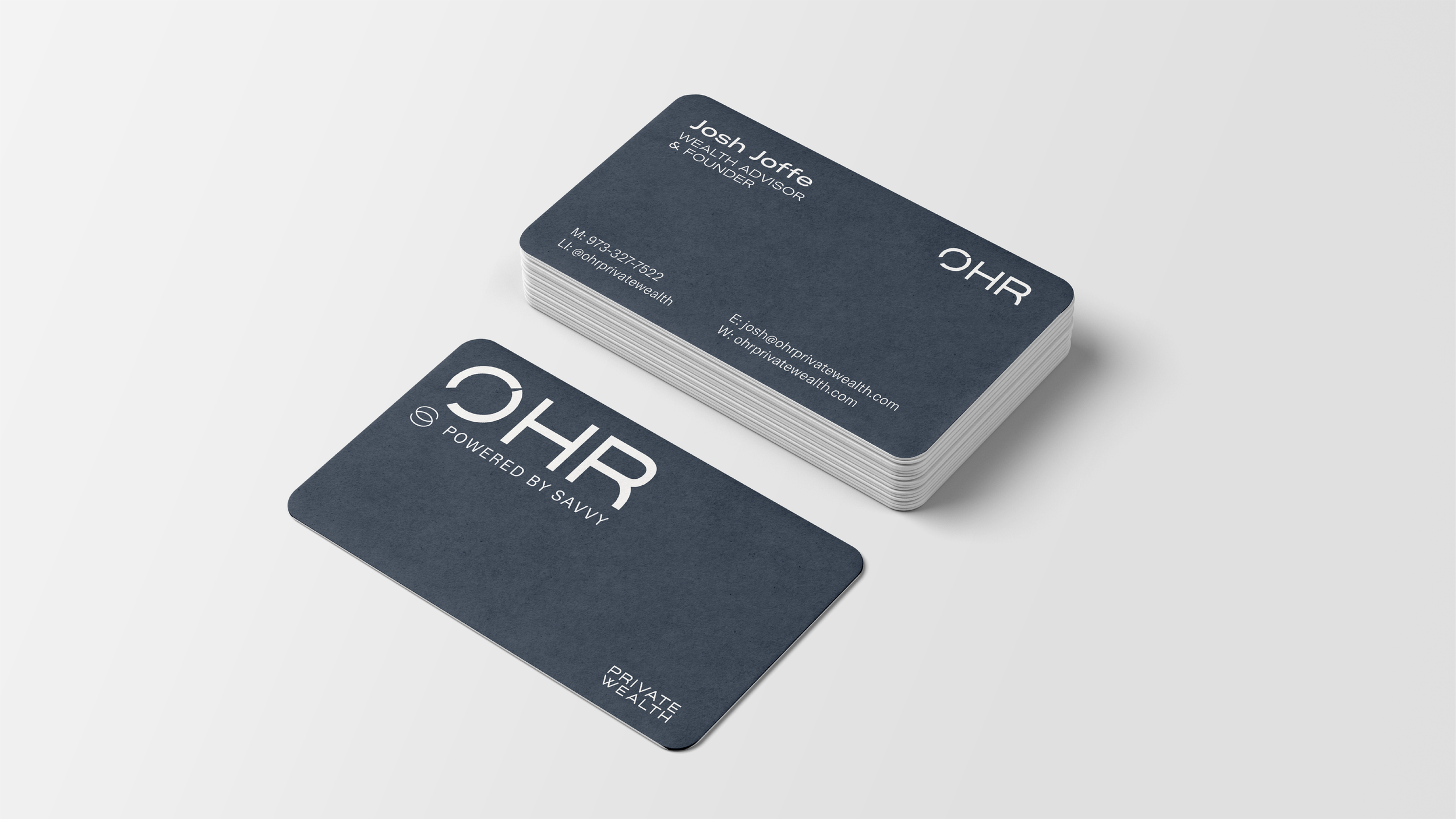 Business cards with the logo 'OHR' and the slogan 'Powered by Savvy,' featuring contact information for Josh Joffe, a wealth advisor, arranged on a light surface.