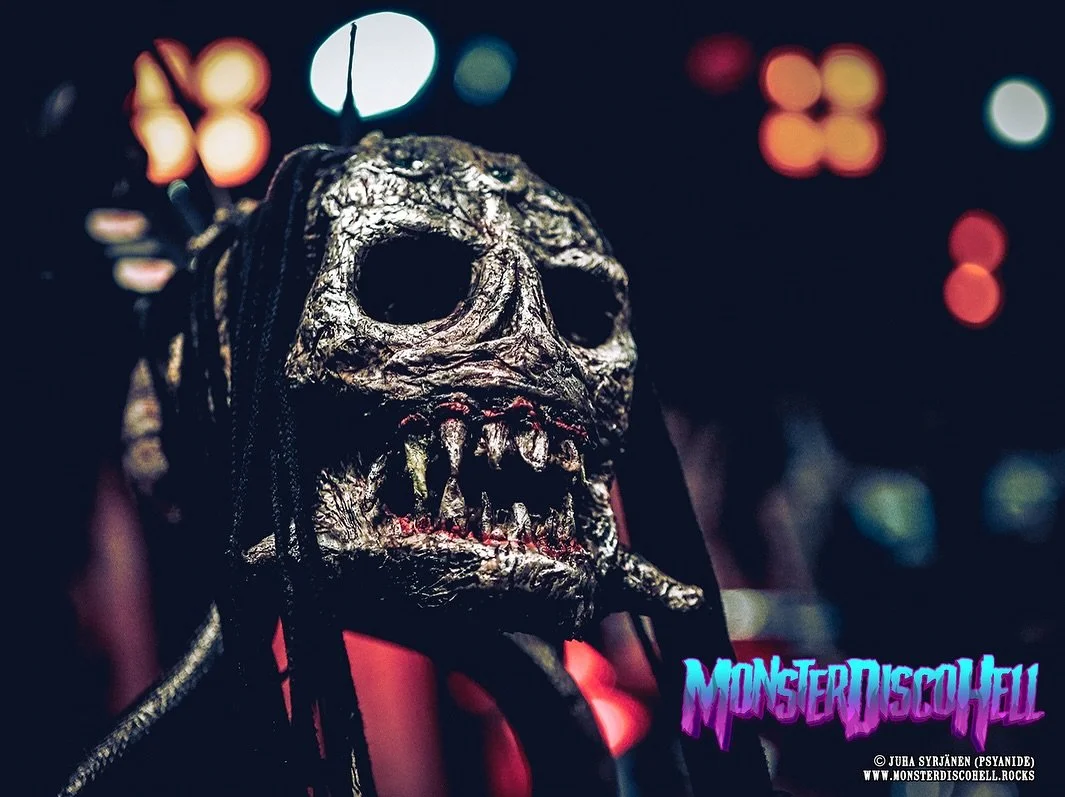 It’s Sunday Sundries time! A week ago I posted a couple of shots of Kone Kallo, the little skull friend hanging from the guitarist’s mic stand. Of course Hiisi has one too! Does this little fetish have a name too? I can’t remember.