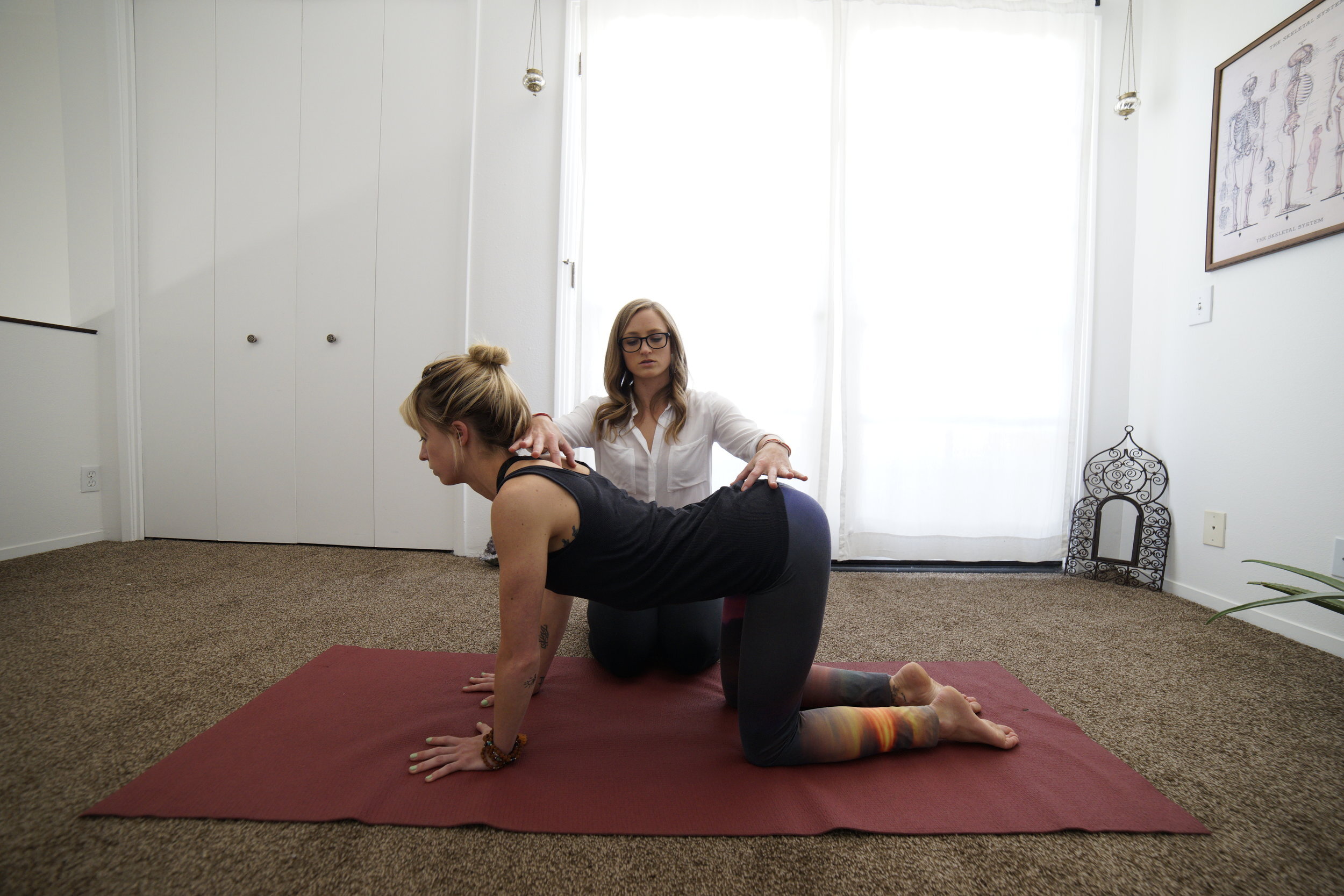Dr. Casie Danenhauer Humble helping someone with cat and cow yoga pose