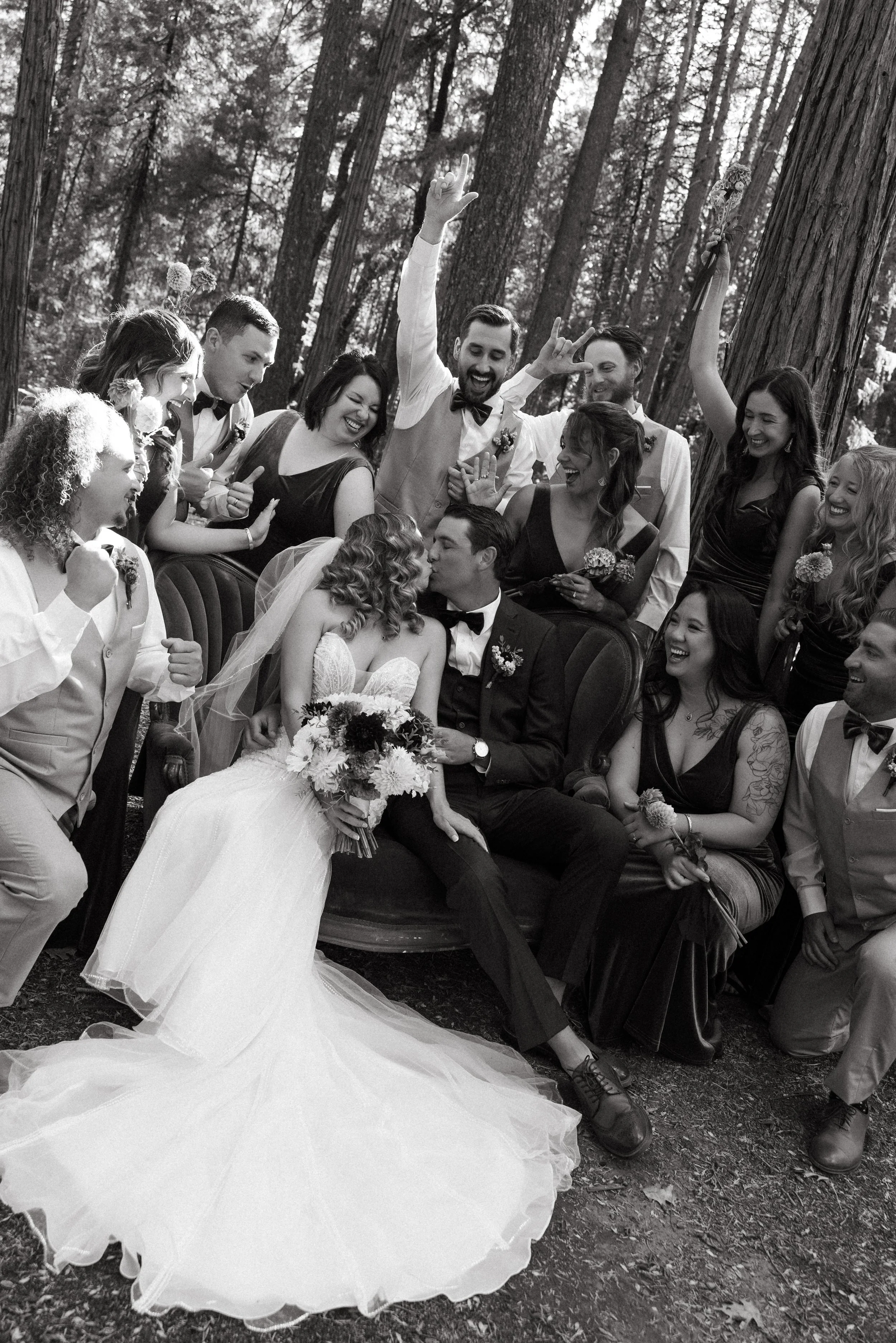 A joyful Wedding party photo of the bride and groom kissing at the Harmony Ridge Lodge in Nevada City